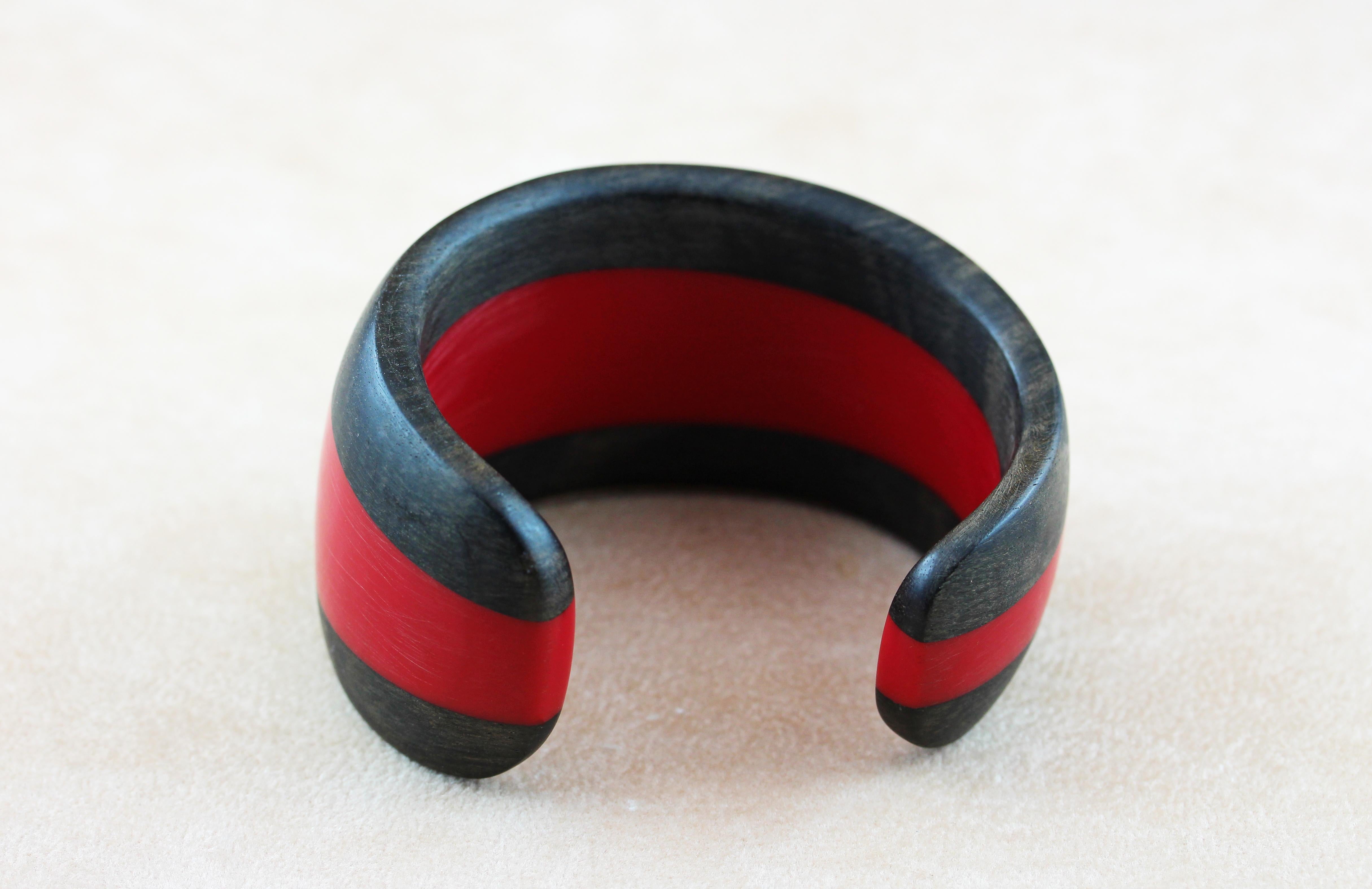 This modern and spectacular bracelet is totally hand carved made in wood and red methacrylate.

Dimensions: 
                    Circumference inside is 16.5 cm circa 
                    Highest part: 4 cm circa 
                    Lower part:  3
