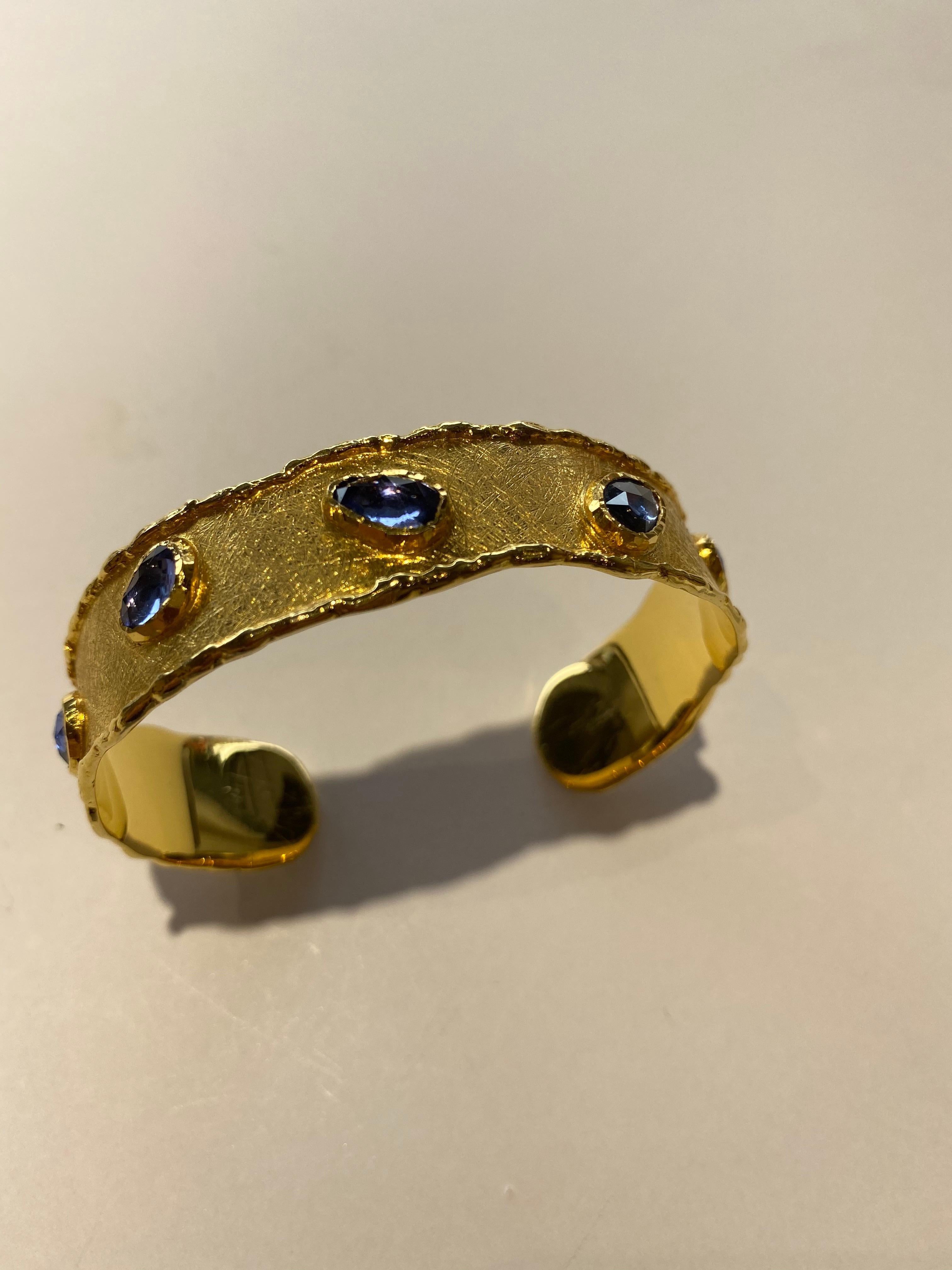 Inspired by the energy pulsating throughout nature, Velyan unites pure metals and gemstones into stunning styles that display the grandeur of fine jewelry. 

This cuff style bracelet features blue sapphires (5.01ct) set in 24k and 18k yellow