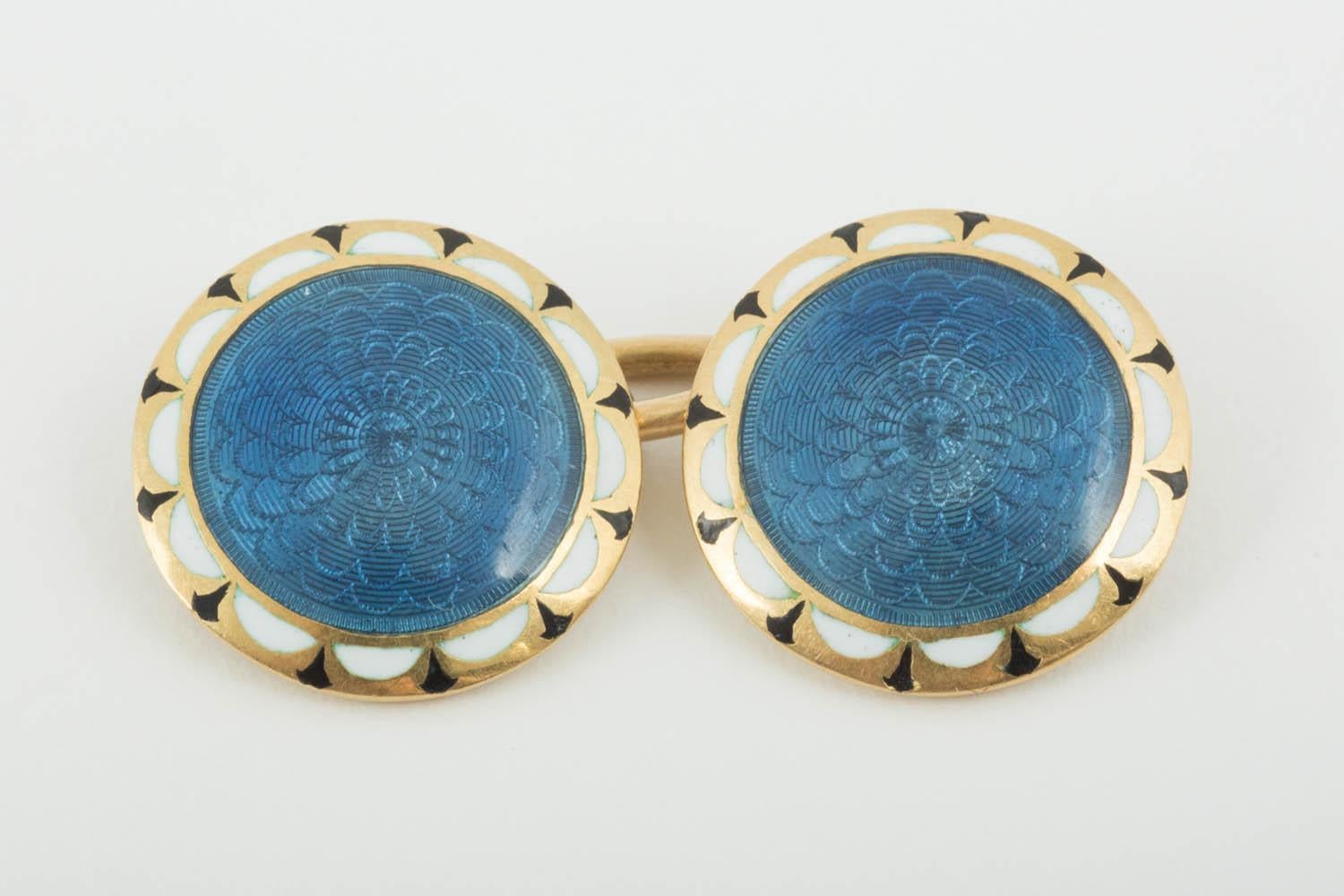 Pair of 18 carat yellow gold [stamped] double sided circular cufflinks,the face with a bright blue floral guilloche enamel,bordered with black and white enamel.English circa 1910.