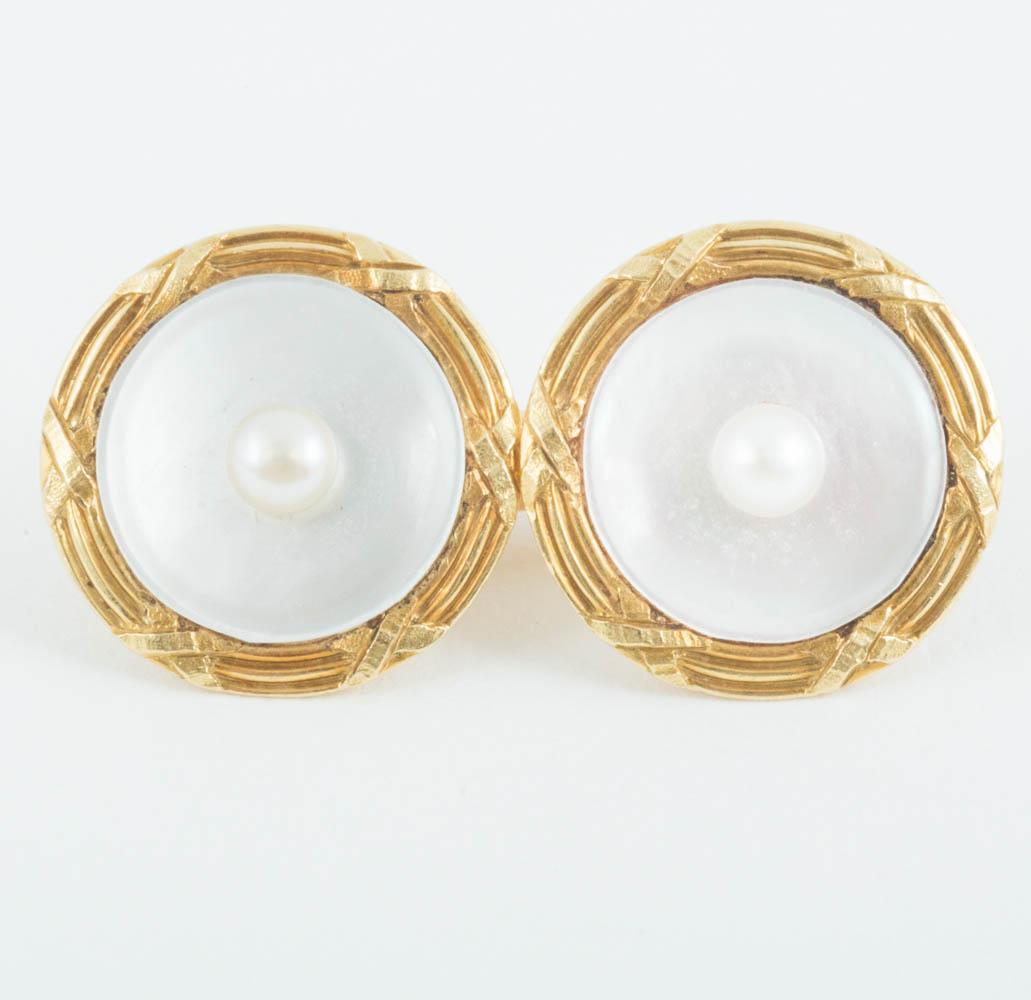 Pair of double sided 18karat yellow gold cufflinks in perfect condition,set with a central natural pearl in a mother of pearl background,the border with a reed and ribbon design. French circa 1900