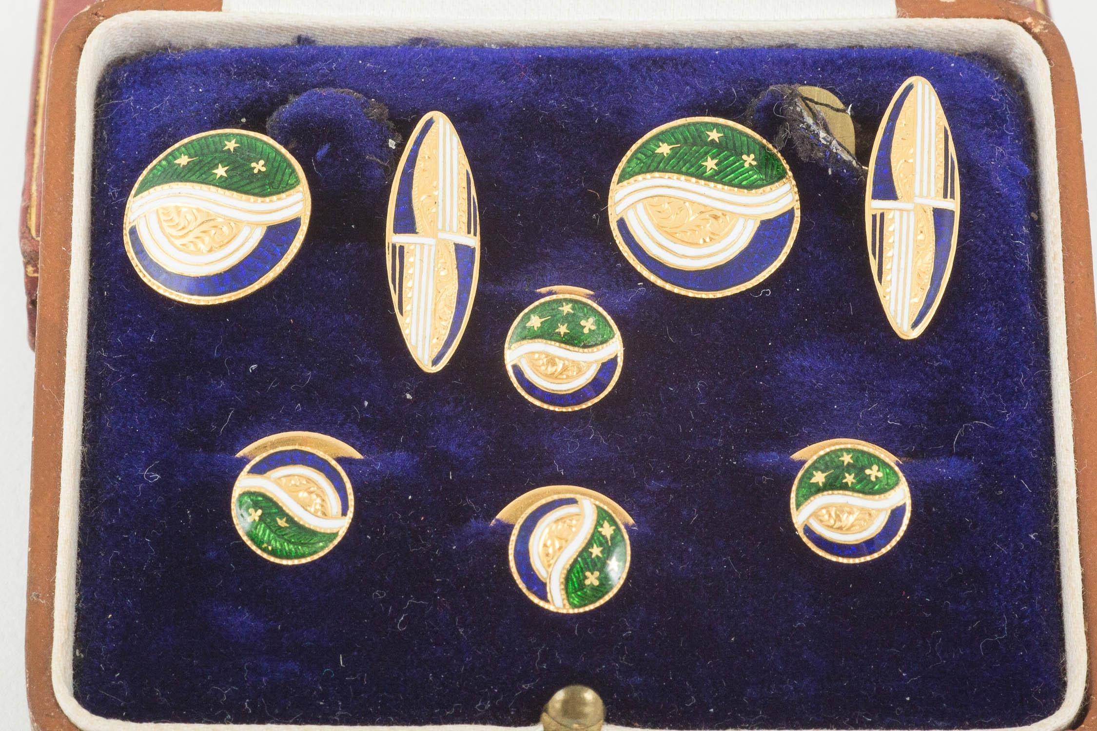 A pair of 14karat gold and brightly coloured blue,white and green enamel cufflinks and 4 matching studs decorated in swirls and stars in a fitted case.cufflinks 13 mm across the centre circular link,and 20 mm length in the boat shaped link. Marks