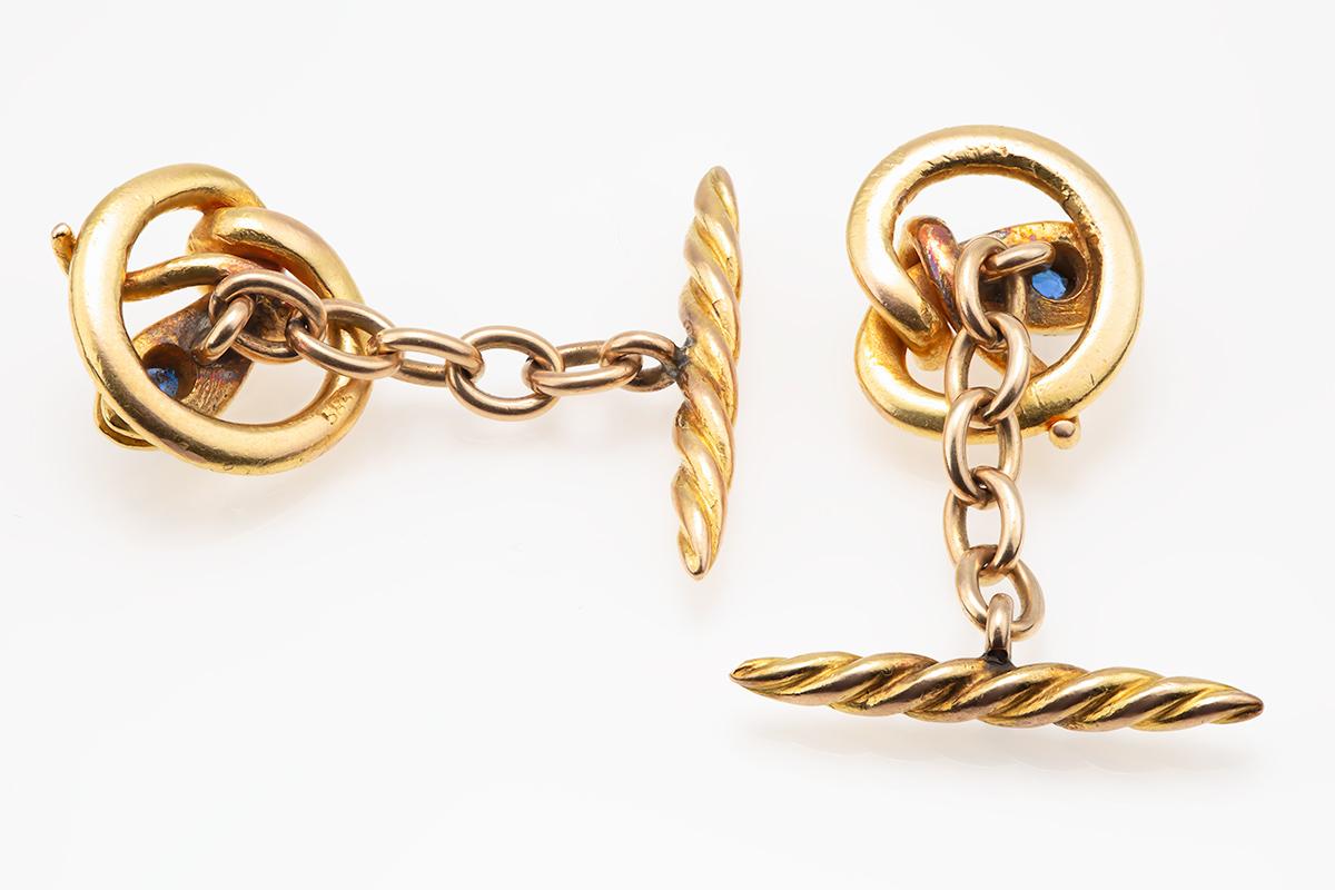 A pair of  heavy quality antique cufflinks in 14 karat yellow gold. Circular in shape and of a coiled serpent set with a facetted Ceylon sapphire to the head. Single sided with a spiral baton terminal and a chain link connection. Stamped 585 (14kt