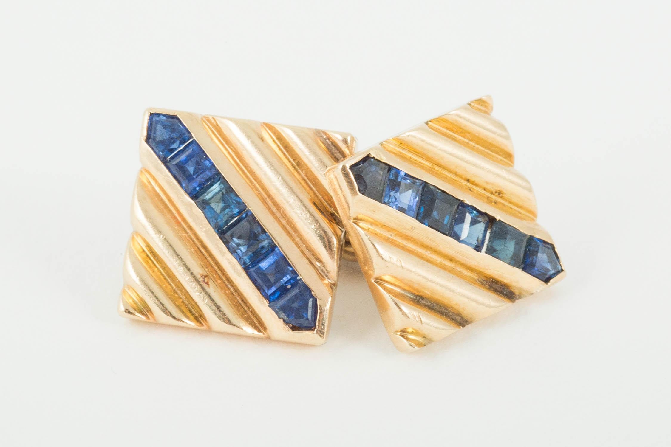 A heavy pair of 14 karat Gold square cufflinks of ribbed design,set with a diagonal line of fine colouredsapphires,chain link connections. Size 12 mm across circa 1950
A heavy pair of double sided, 14 karat yellow gold cufflinks of ribbed design,