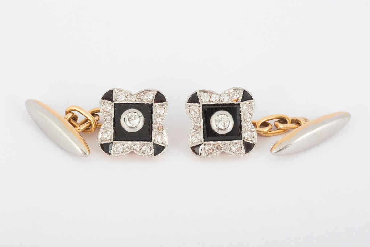 A vintage pair of single sided cufflinks with a torpedo terminal on a chain link. Platinum set with onyx and brilliant cut diamonds in 18 carat yellow gold. This typical 1920’s geometric design is rectangular in shape with rounded edges creating a