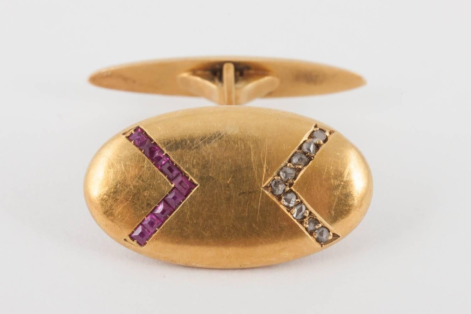 A pair of single sided, antique cufflinks in 18 karat yellow gold with an excellent patina. Set with a v-shaped design of rose cut diamonds and Burma rubies with a boat shaped terminal.
Face of link measures 10mm wide and 20mm in length.
Antique