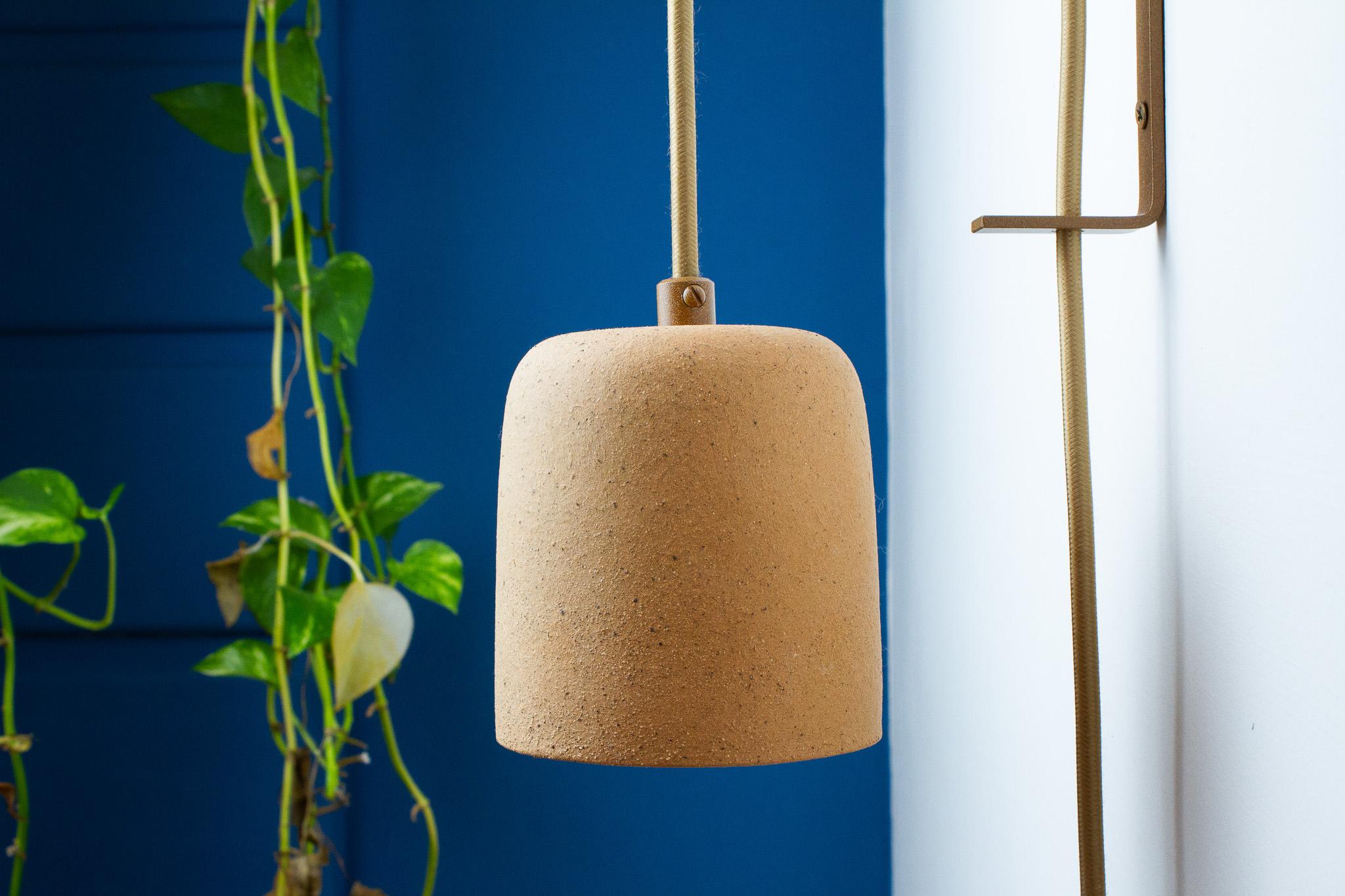 La lampada da parete Cuia fa parte della collezione Romaria, è stata sviluppata da Raísa Anderson, creativa del marchio, e prodotta all'interno di San Paolo, a partire dall'argilla, dalle mani di Luis Airton, un ceramista partner con più di 30 anni