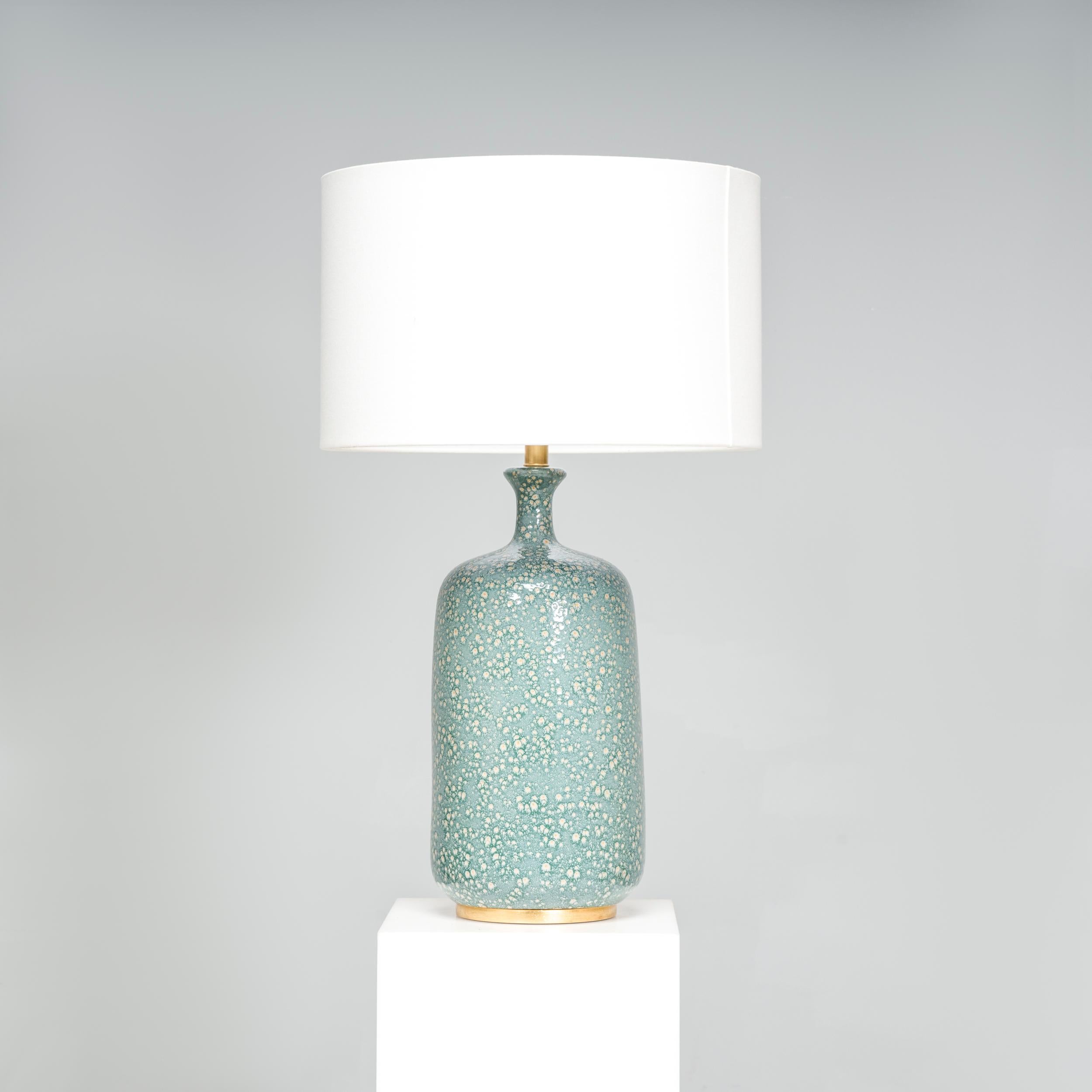 The ceramic table Lamp has a beautiful design that would elevate any living space or bedroom. Made by Visual Comfort designed by AERIN.

 An added touch of sophistication, the brass detailing complements the blue tones of the tall drum shaped