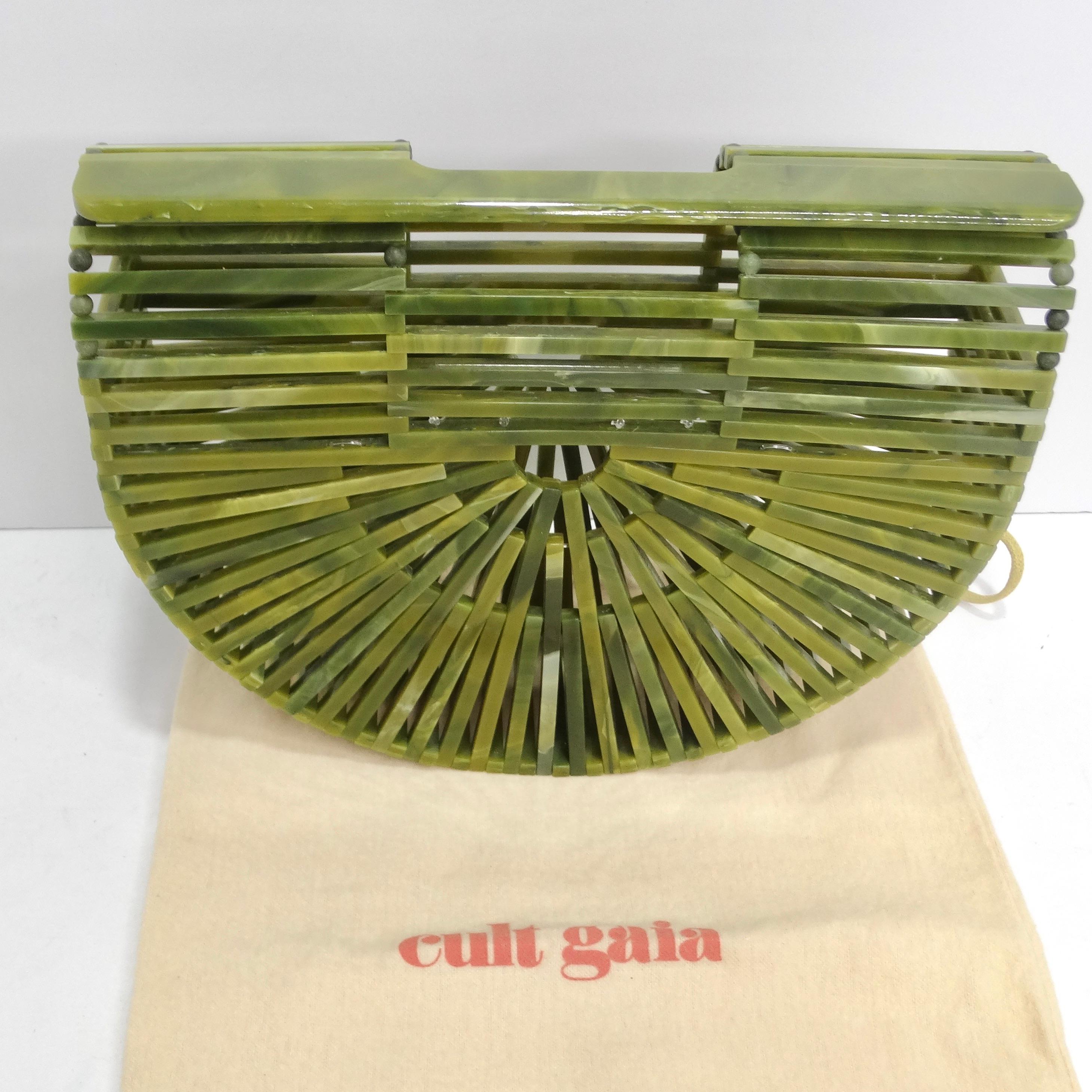 Introducing a clutch that's not just an accessory; it's a work of art - the Cult Gaia Acrylic Ark Bag in Gorgeous Green. This clutch takes fashion to a new level with its signature sun ray motif in glossy jade acrylic, meticulously handcrafted to