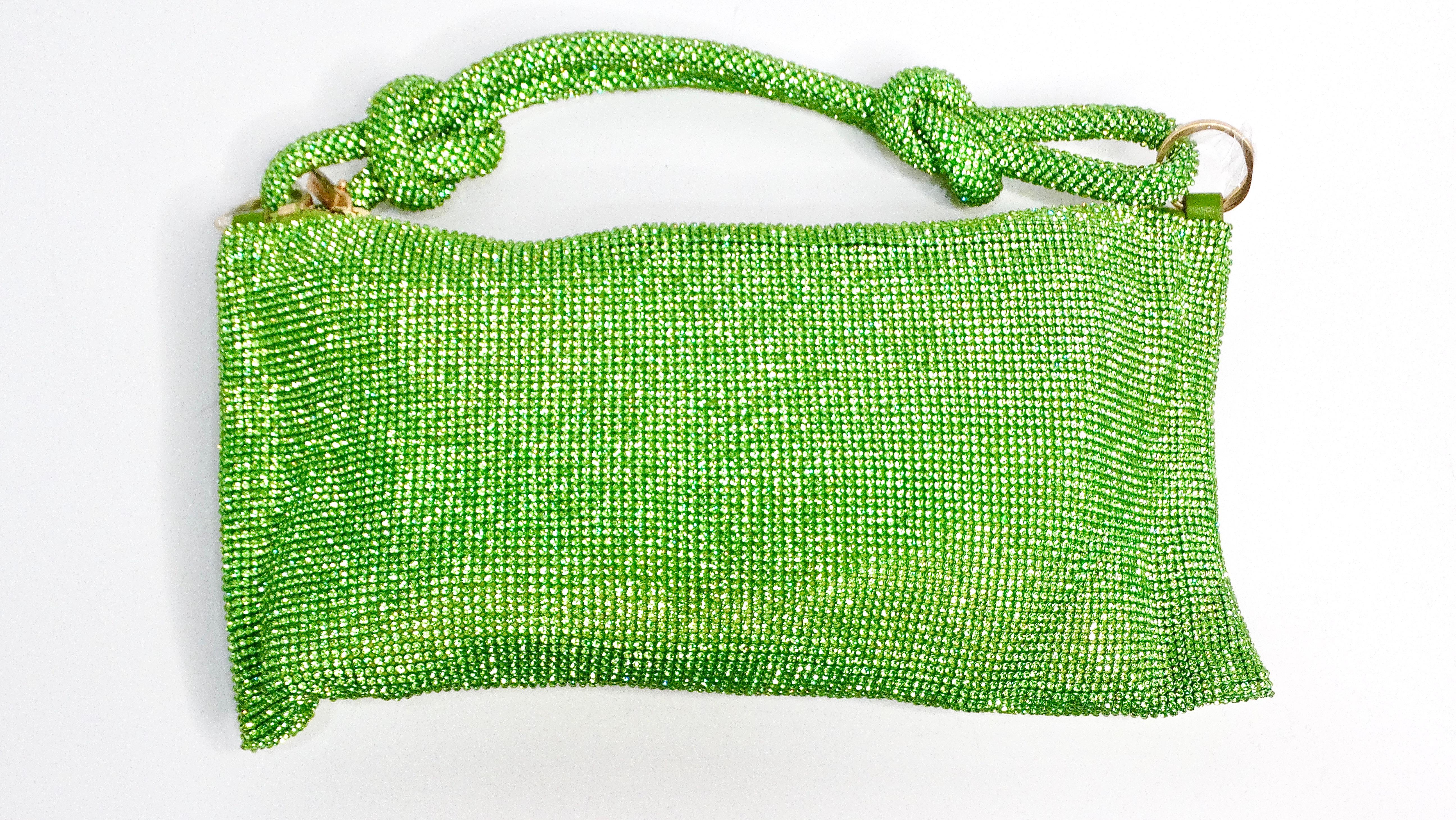 The Cult Gaia Green Nano Hera Crystal Handbag is a dazzling statement piece that effortlessly elevates any evening ensemble. Adorned with sparkling crystals and complemented by gold-tone hardware, this handbag exudes luxury and glamour. The leather