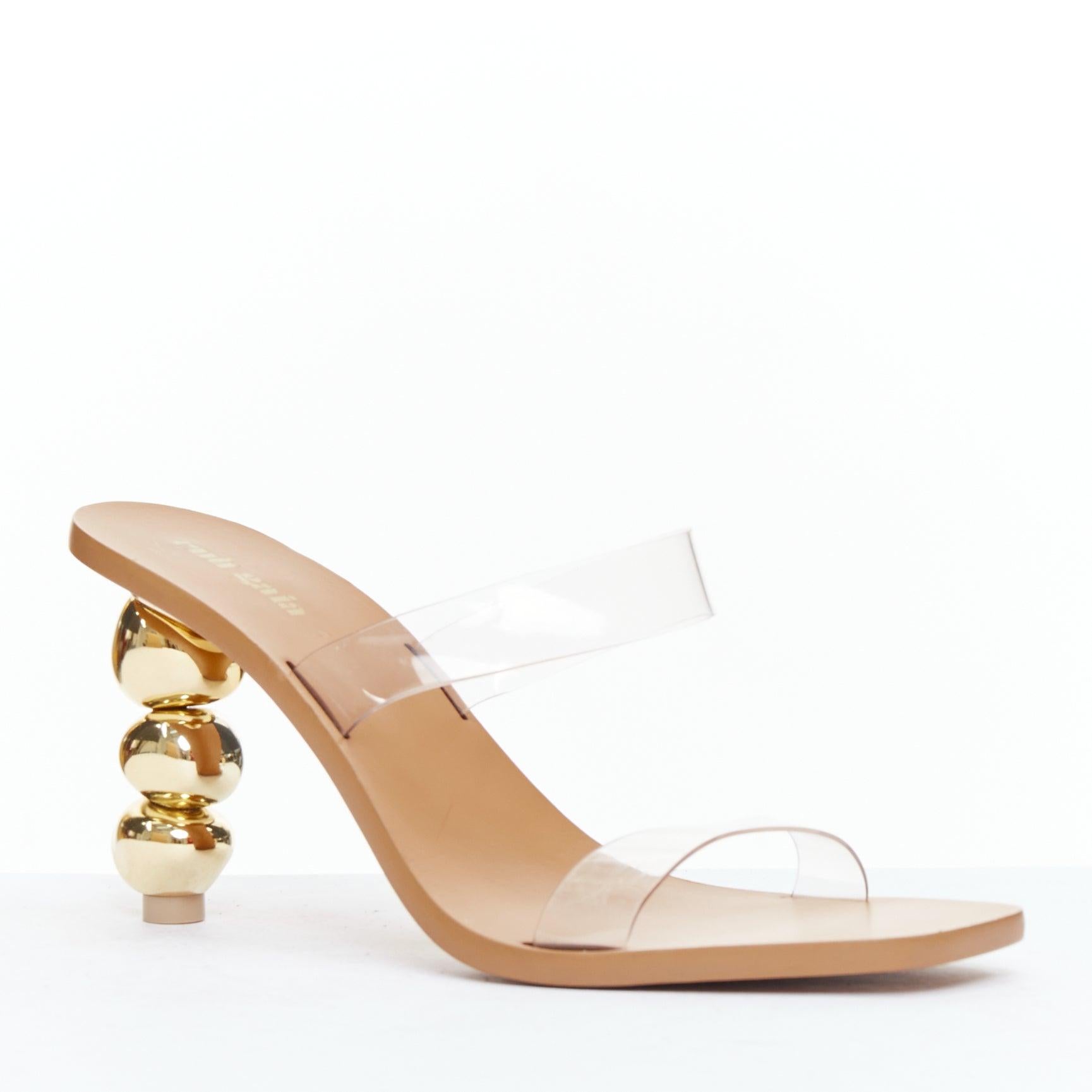 CULT GAIA Meta gold sculptural heel clear PVC mule sandals EU38
Reference: ECLO/A00121
Brand: Cult Gaia
Model: Meta
Material: PVC, Metal
Color: Clear, Gold
Pattern: Solid
Closure: Slip On
Lining: Brown Leather
Extra Details: Gold architectural