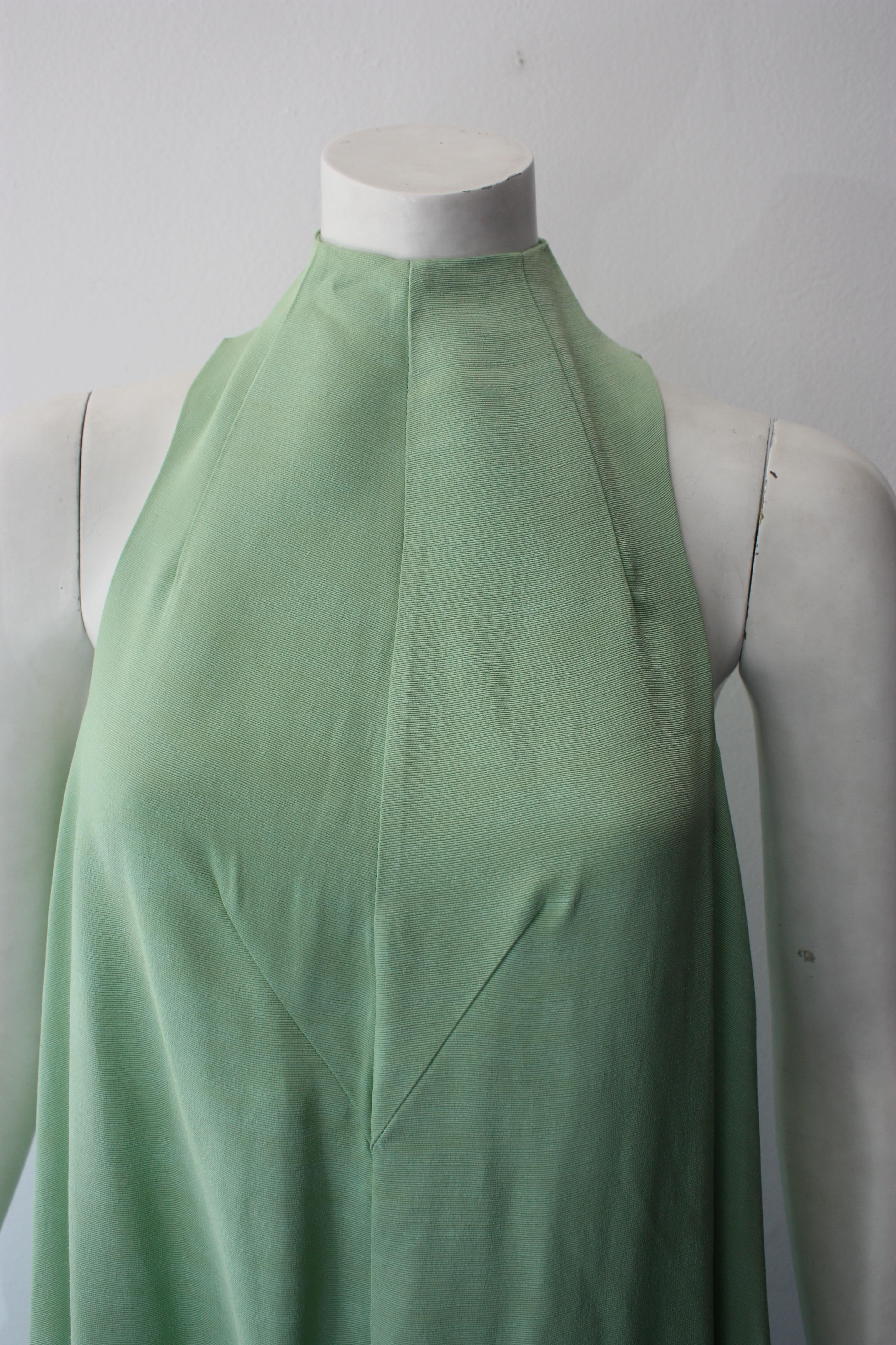 Mintgrünes ärmelloses Kleid von Cult Gaia. Mokka-Ausschnitt. Asymmetrisch drapierter Saum. Verdeckter Reißverschluss am Rücken und Bindeband im Nacken. 
Größe M
100% Viskose.
Neu mit Tags.