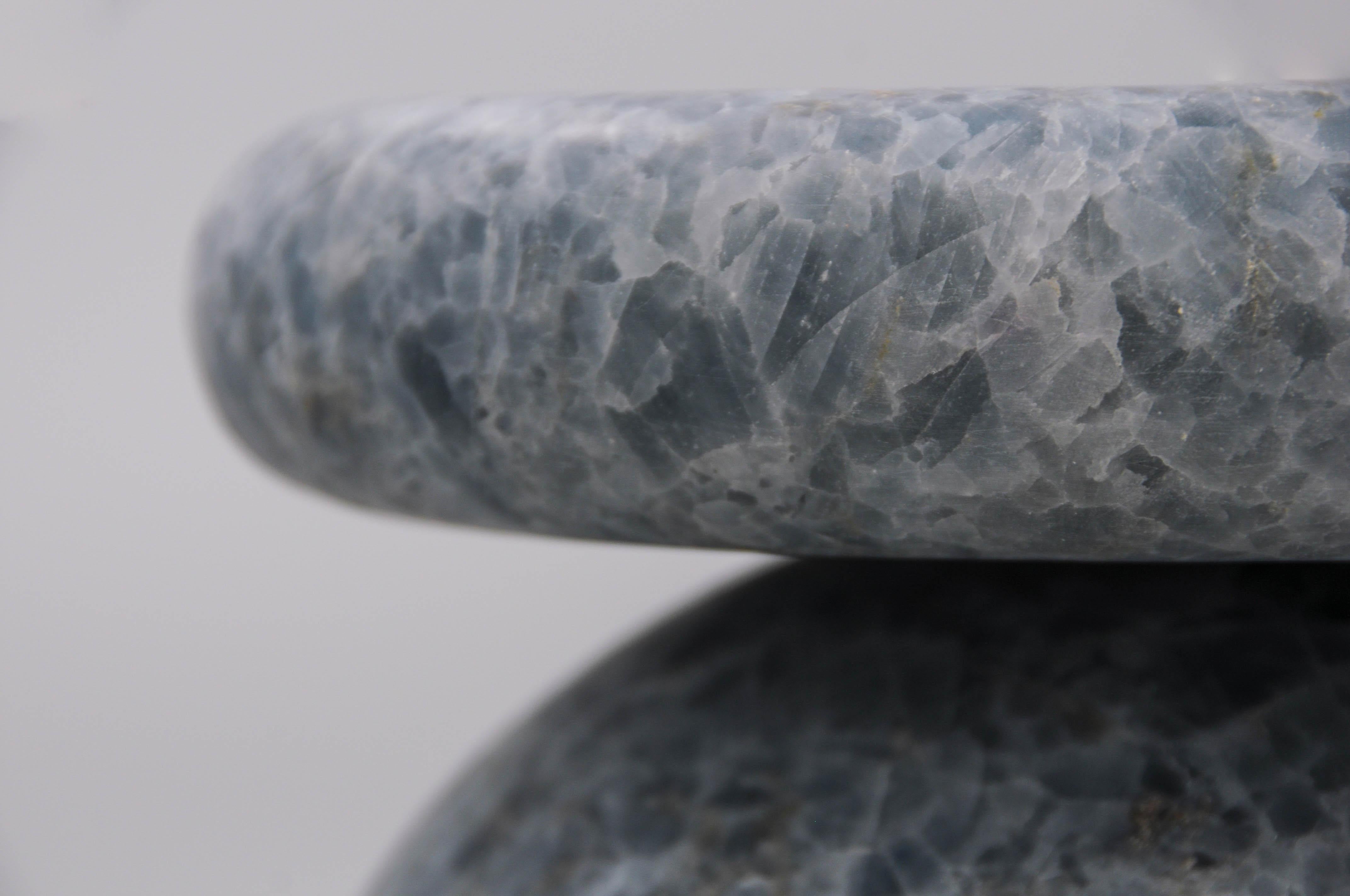 Cult stool/ side table; a hand sculpted stone from a Mexican Blue Calacite, remits to primal sculptural-architectural language while displaying materials in a modernist manner. The piece allows for the specificity of the material’s eccentric pattern