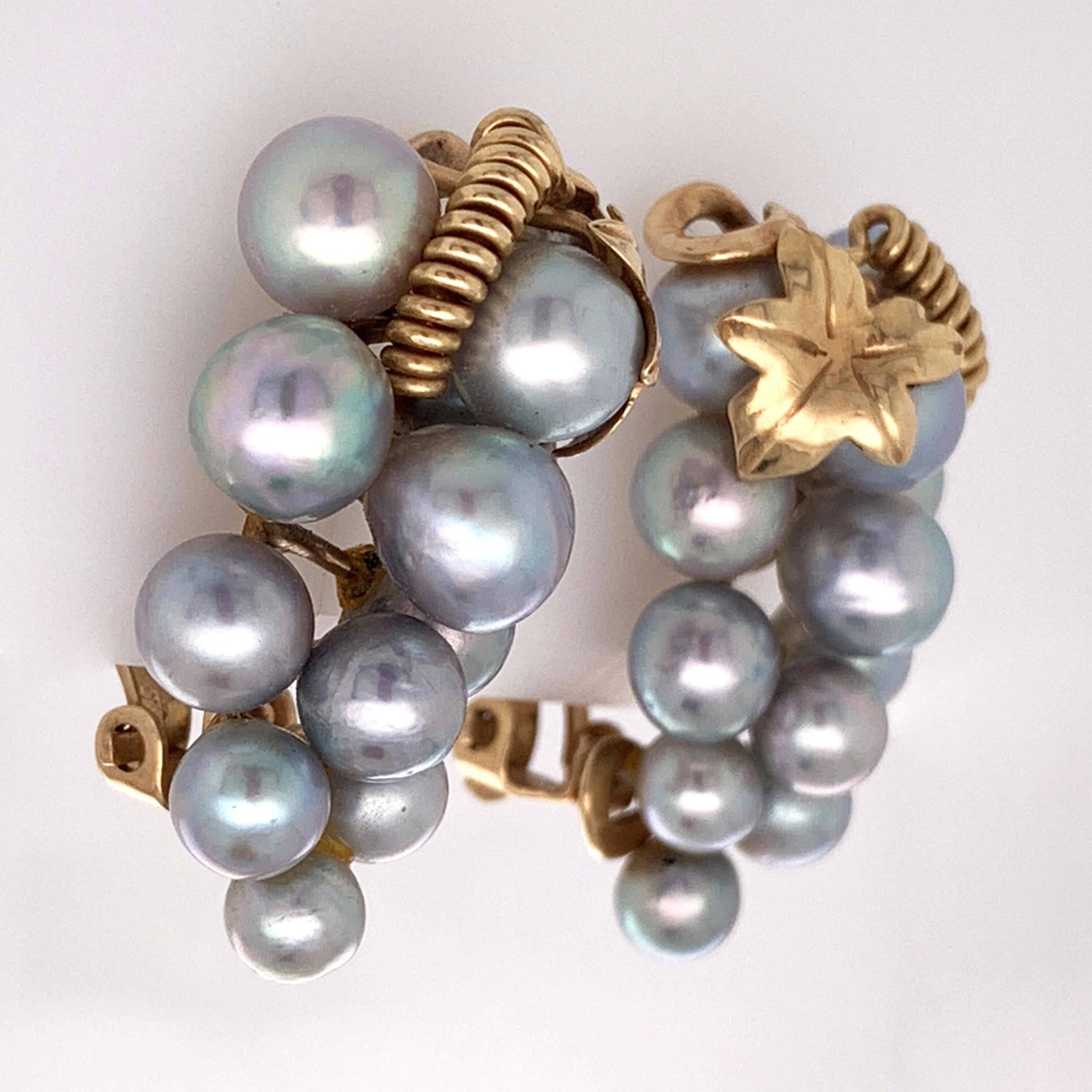 Pictured above is an unique and lovely pair of vintage 14 karat clip on pearl cluster earrings. Each earring features 12 lustrous pearls gathered together so as to imitate a decadent cluster of grapes hanging delicately off the vine, and each is