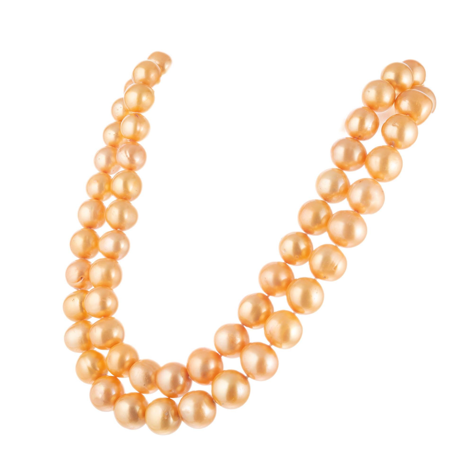 Golden yellow natural color 36-Inch-long Chinese cultured freshwater pearl necklace 11mm to 13mm. Moderate blemishes. Slightly uneven natural color. 14k yellow gold catch.

72 Chinese cultured orange golden pearls, 11mm to 13mm 
Chain: 36 Inches
14k