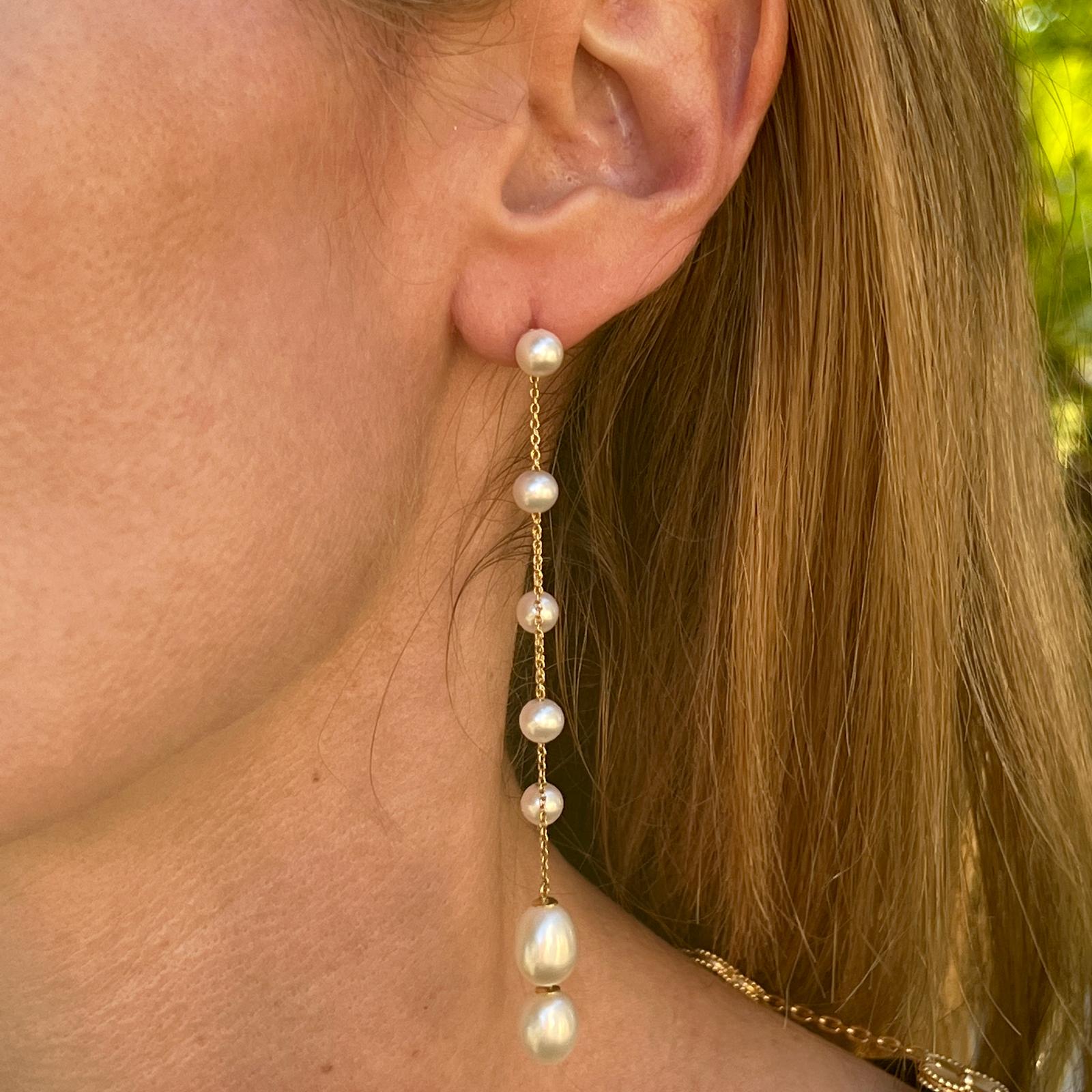 Pearl drop dangle earrings fashioned in 14 karat yellow gold. The earrings feature multi-strands of gold and cultured pearl drops measuring 3.5 inches in length. 