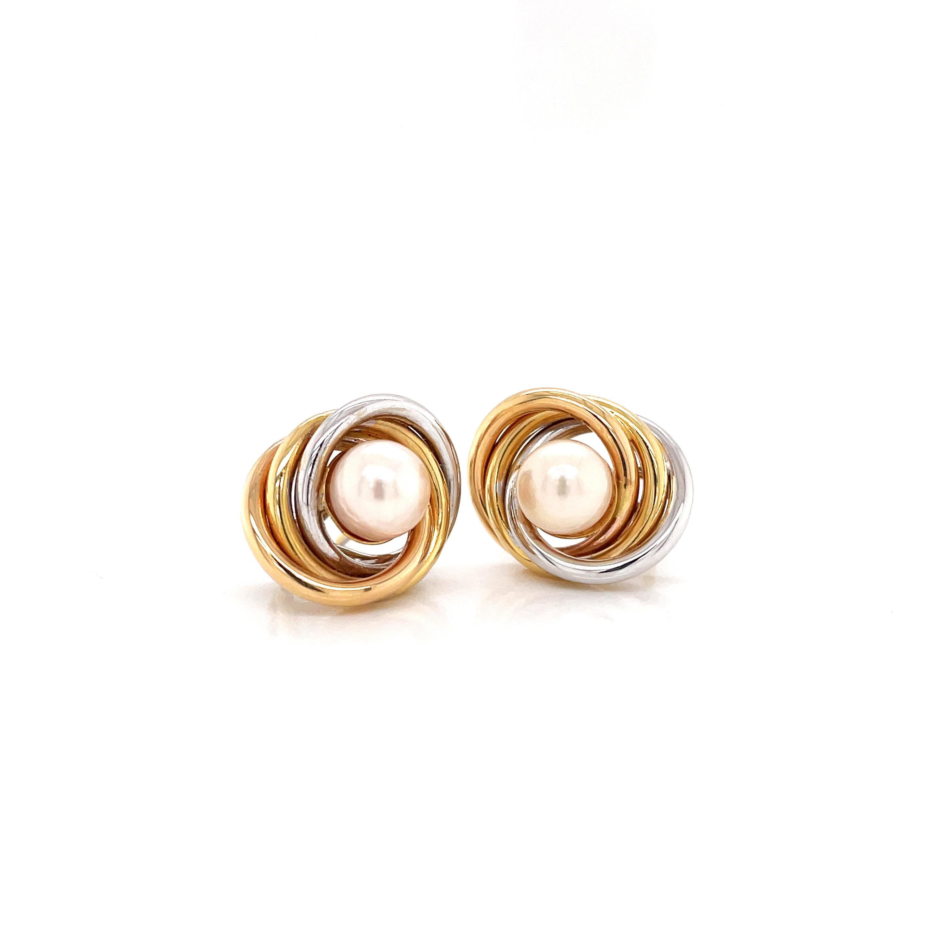 These gorgeous stud earrings feature a cultured pearl measuring 7mm set in the center of three 18 carat gold rings, one white, one rose and one yellow intertwined beautifully creating a solid frame. The earrings are finished with a secure French