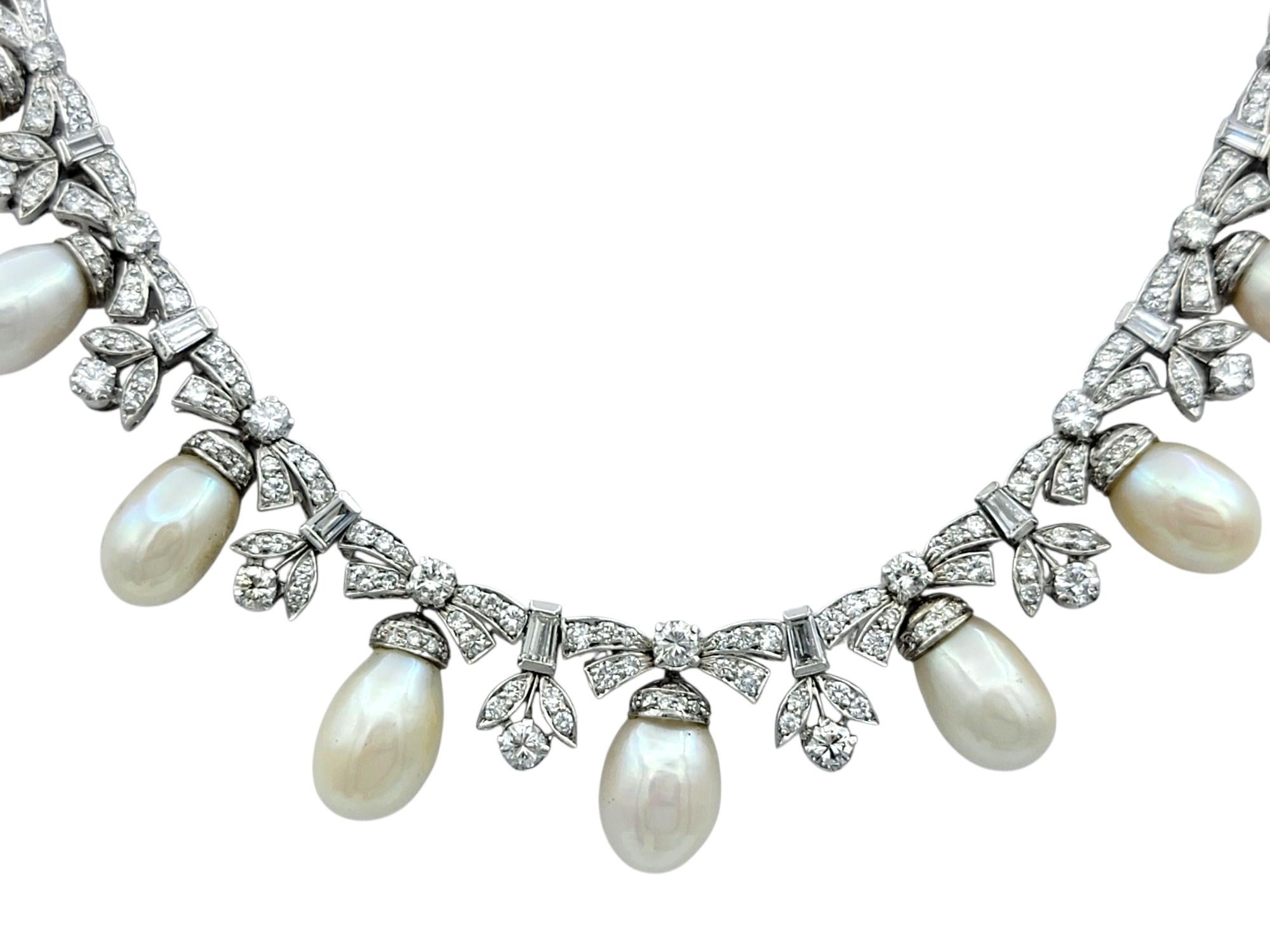 This ornate choker necklace makes a striking impression with its cascading design of white cultured pearls and diamonds. The elegant arrangement of teardrop-shaped freshwater pearls drapes gracefully along the neckline, each suspended beneath a