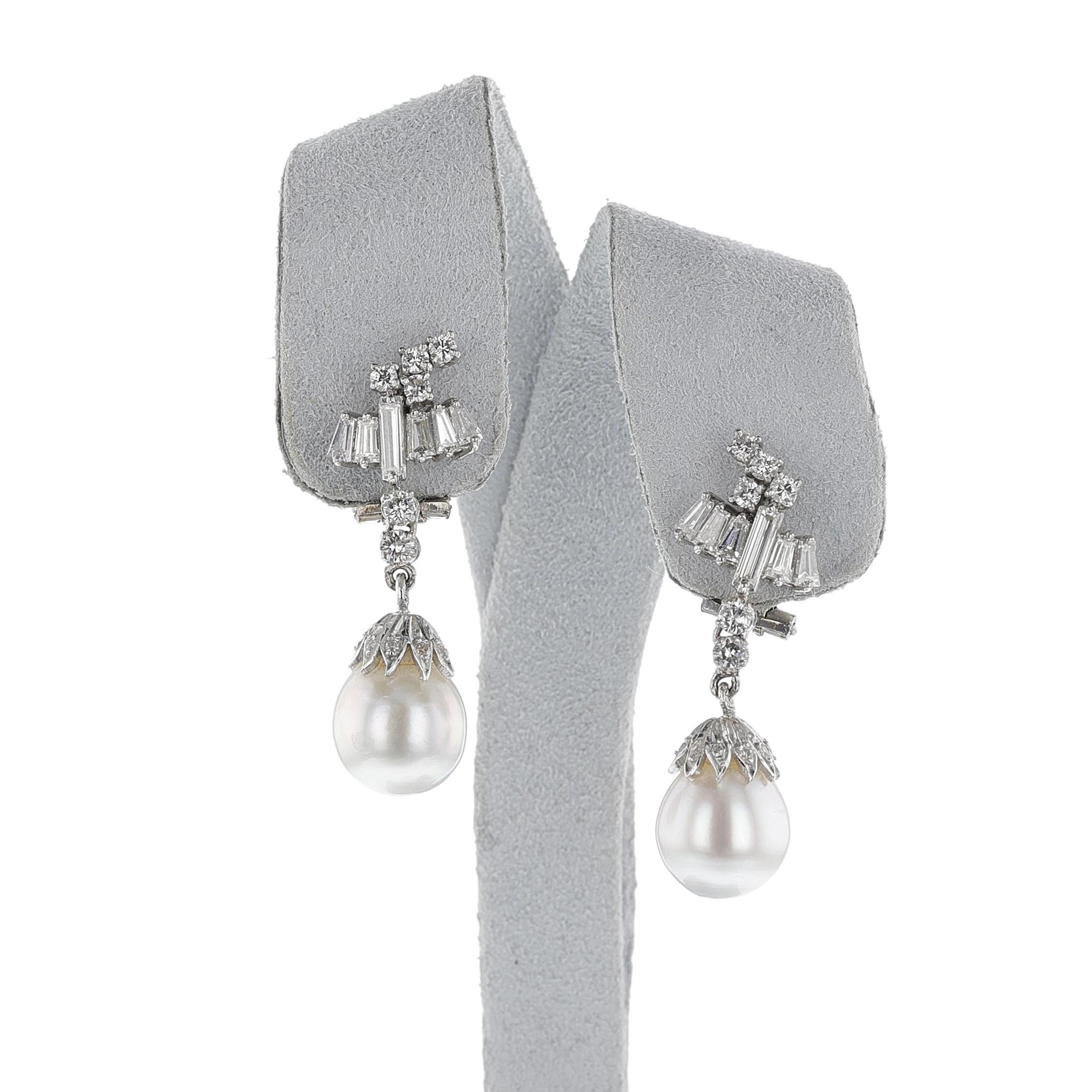 A pair of Cultured Pearl and Diamond Dangling Earrings made in 18k Gold. There are baguette and brilliant-cut diamonds with a hanging cultured pearl. French Import Marks. Length is 1.50 inches. The total weight of 12.48 grams.