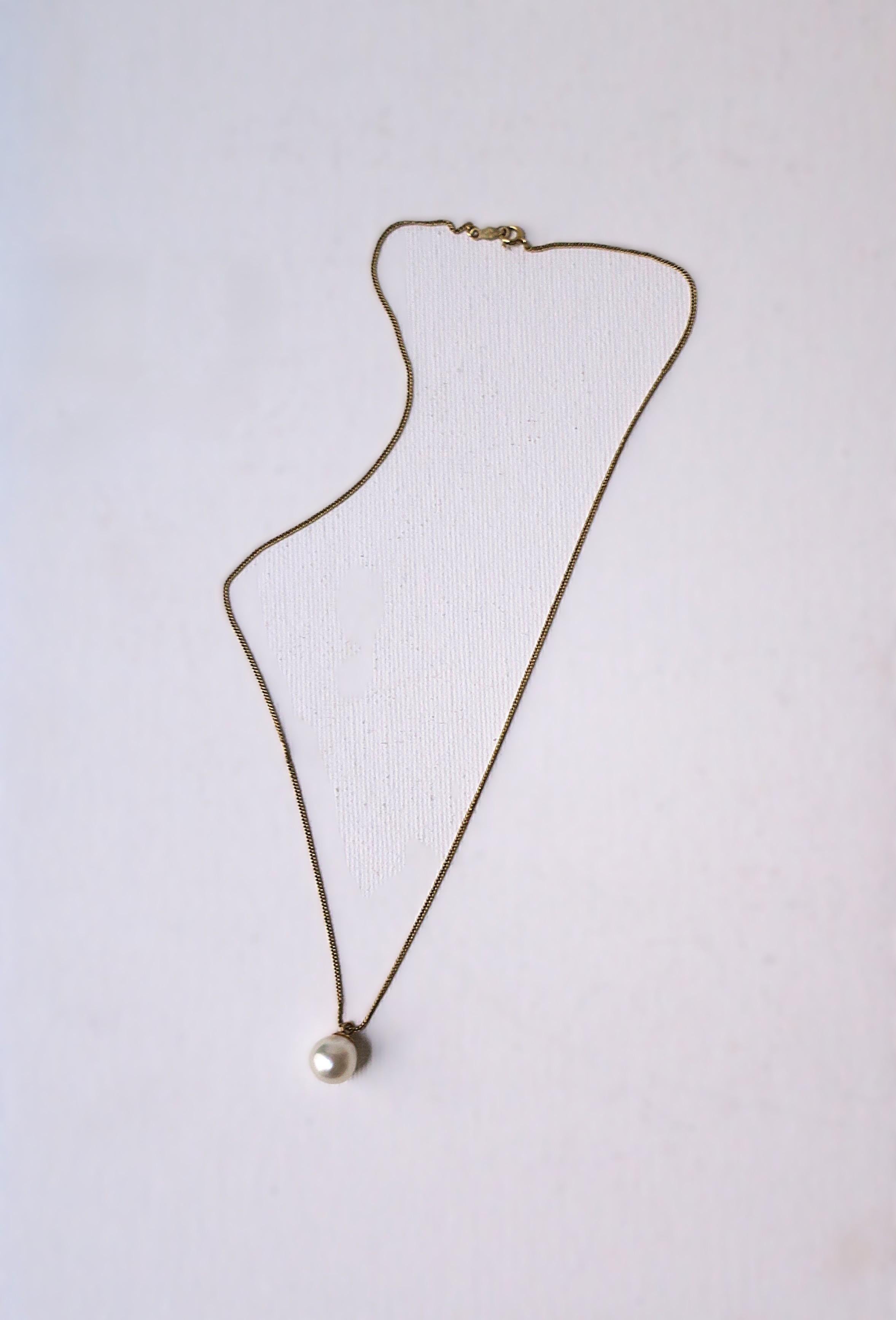 A very beautiful white cultured pearl and 14kt yellow gold pendant necklace, circa mid to late-20th century. Pearl is beautiful with a high luster; pearl is a nice size measuring 9.65mm. Necklace length is 16