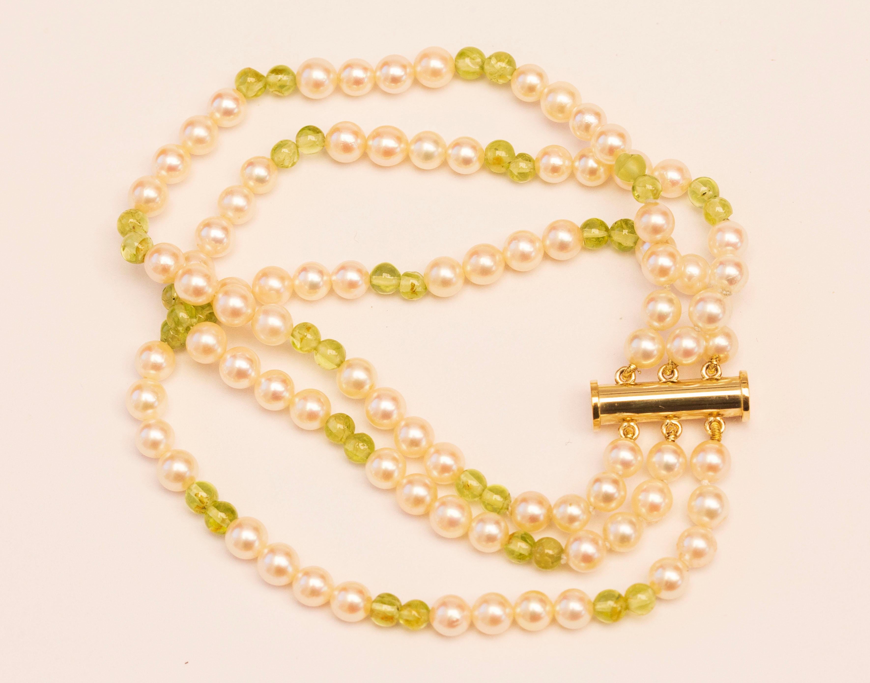 A vintage triple strand cultured pearl and peridot bracelet with 14 karat yellow gold magnetic closure. The bracelet was manufactured by the German JKa Kohle Company of Pforzheim in CA. 1970s. The closure is stamped with JKa and 585 that stands for