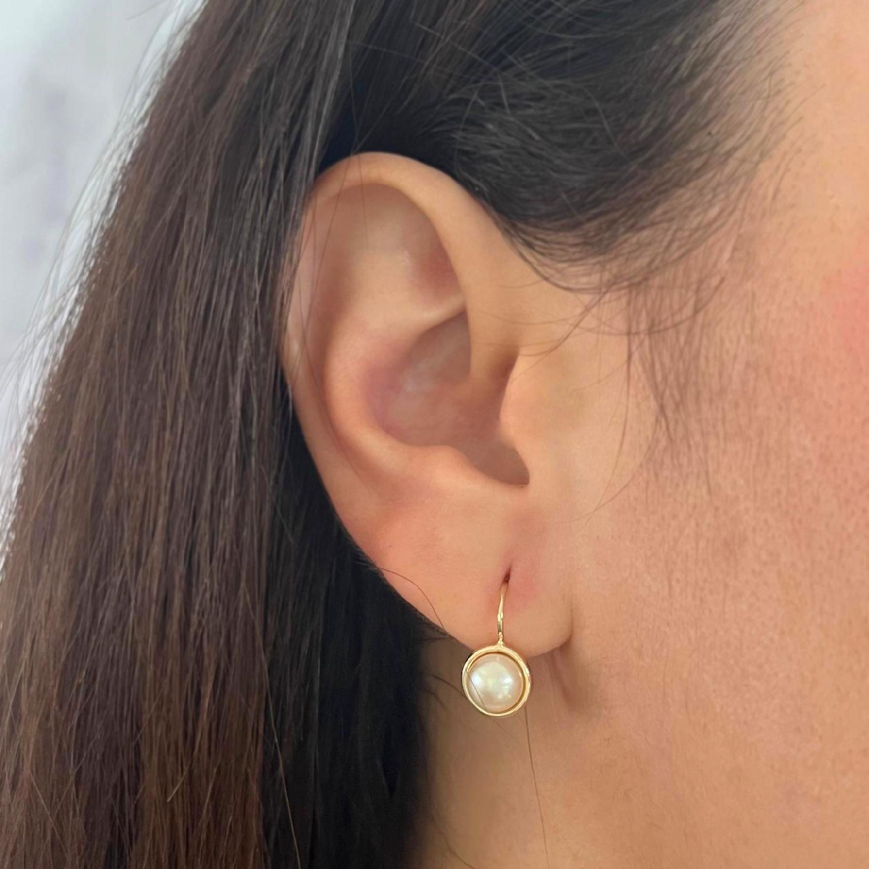 Lightweight 14 karat yellow gold drop earrings featuring two 6.5mm white button cultured pearls. French wire with hinged closure. Finished weight is 1.7 grams.