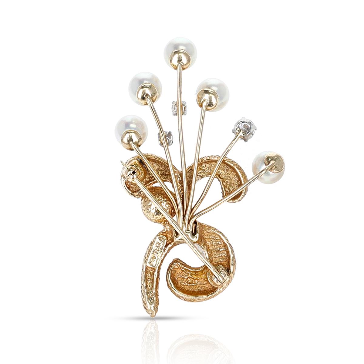 An artful and earthy cultured pearl and diamond brooch set in 14K Yellow Gold, with six round cultured pearls measuring 6.5-7MM accented with three round diamonds totaling 0.45 carats. Stamped 
