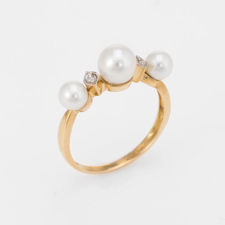 Elegant vintage cultured pearl & diamond band, crafted in 14 karat yellow gold. 

Cultured pearls graduate in size from 4.5mm to 6mm, accented with an estimated 0.01 carats of diamonds (estimated at H-I color and VS2-SI1 clarity). The pearls are