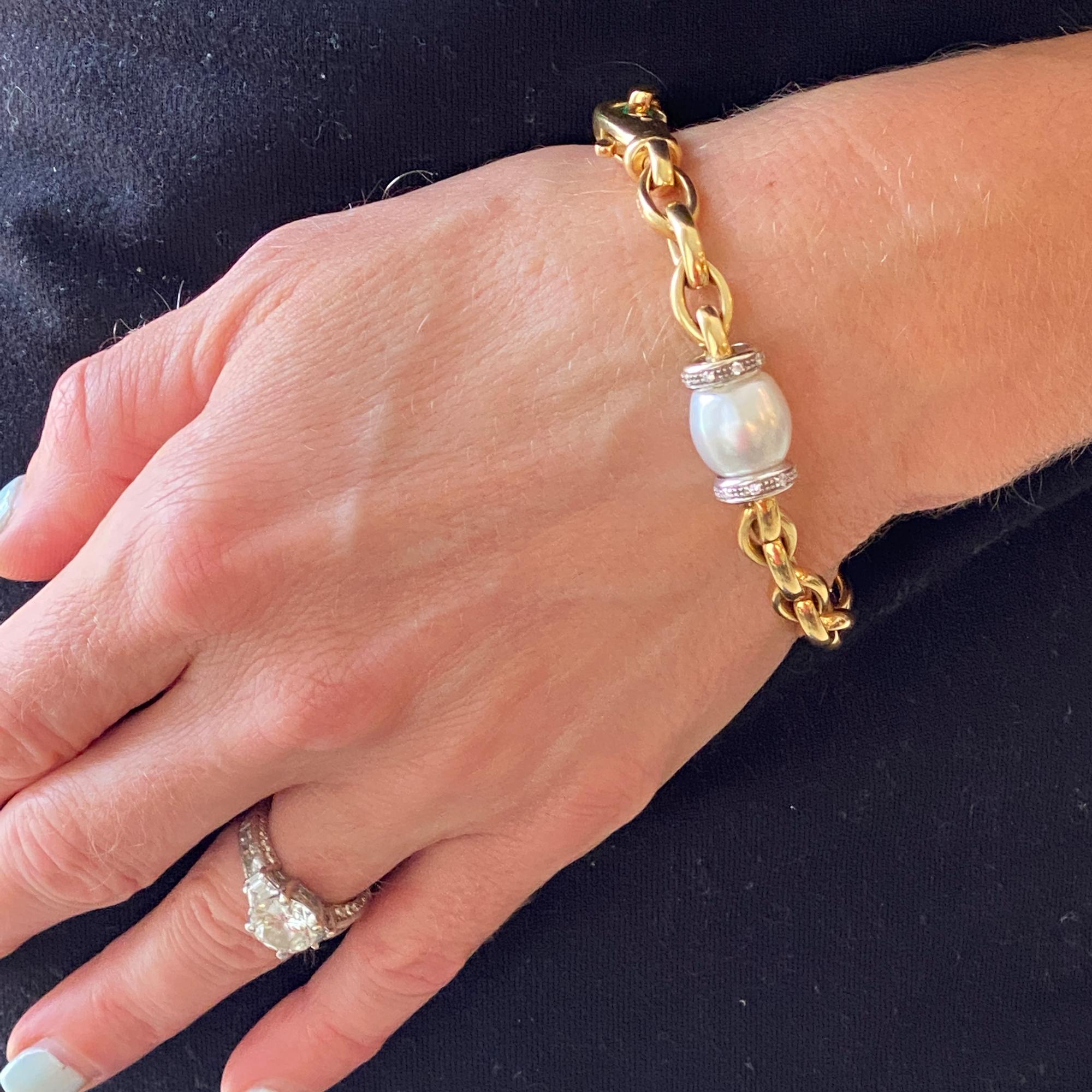 Beautiful cultured pearl diamond station oval link bracelet crafted in solid 18 karat yellow gold. The 12mm pearl is flanked by 16 round brilliant cut diamonds weighing .16 carat total weight. The bracelet measures 7 inches in length.
