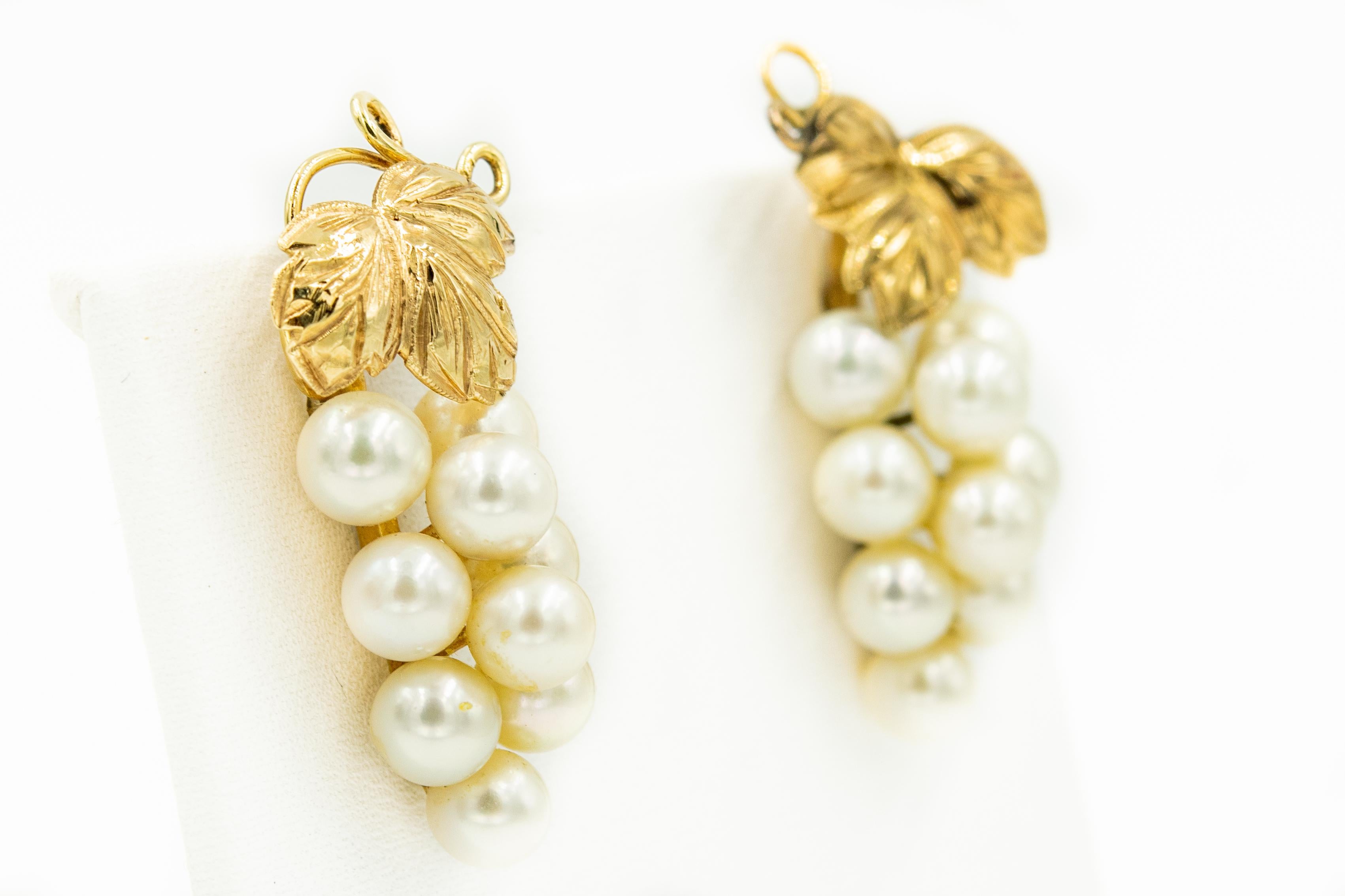 Lovely grape earrings each composed of 9 cultured pearls (approximately 5.5mm each) that hang from 3 leaves and gold vines that are made of 14k yellow gold.  The backs of the earrings have a post and come with clear earring backs.