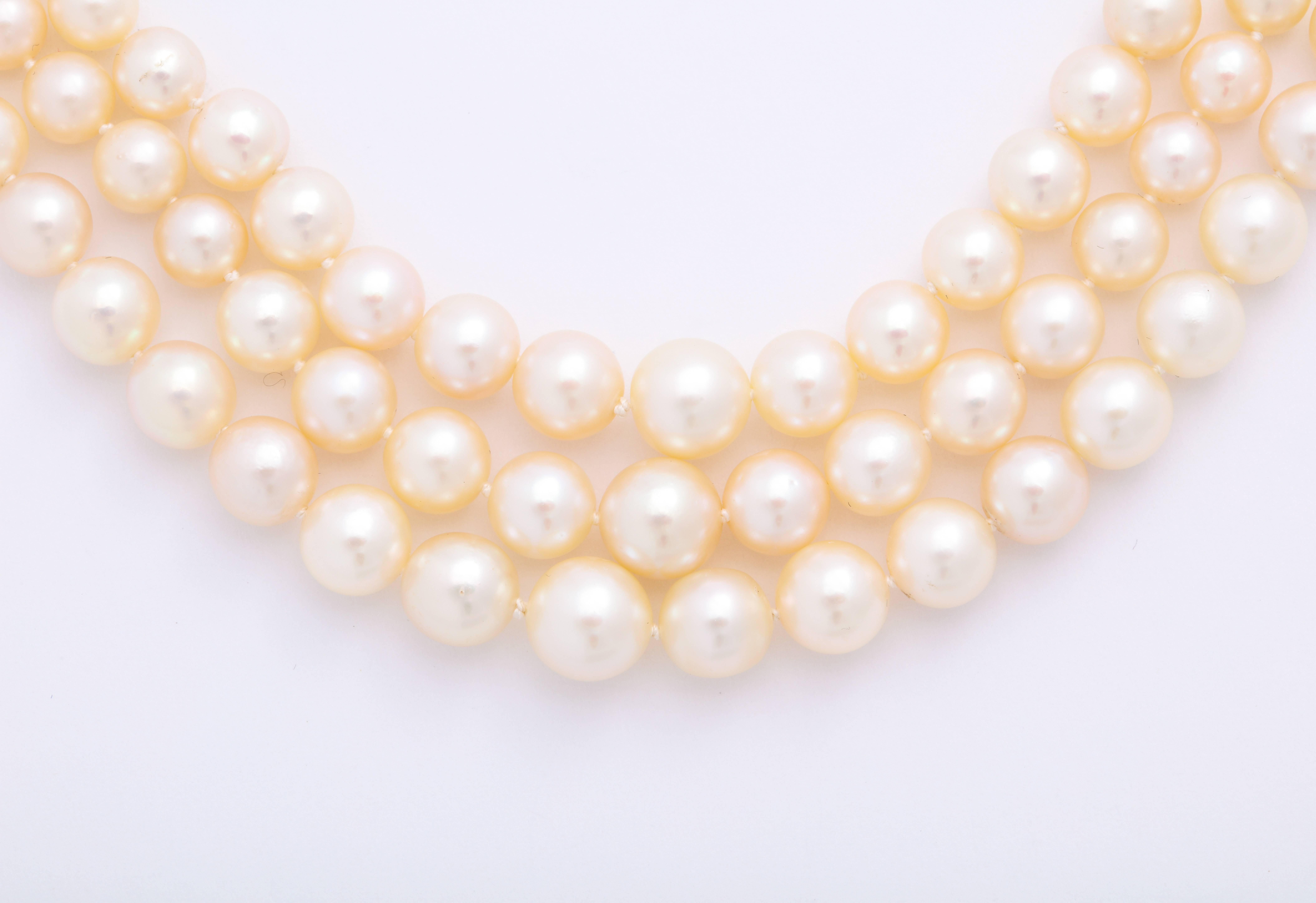 A 3-row cultured pearl necklace ranging from 4.2mm - 8.16mm. The clasp is vintage, silver-topped 18 karat yellow gold with a button pearl center surrounded by 12 old mine cut diamonds weighing an estimated 1.80 carats in total. 