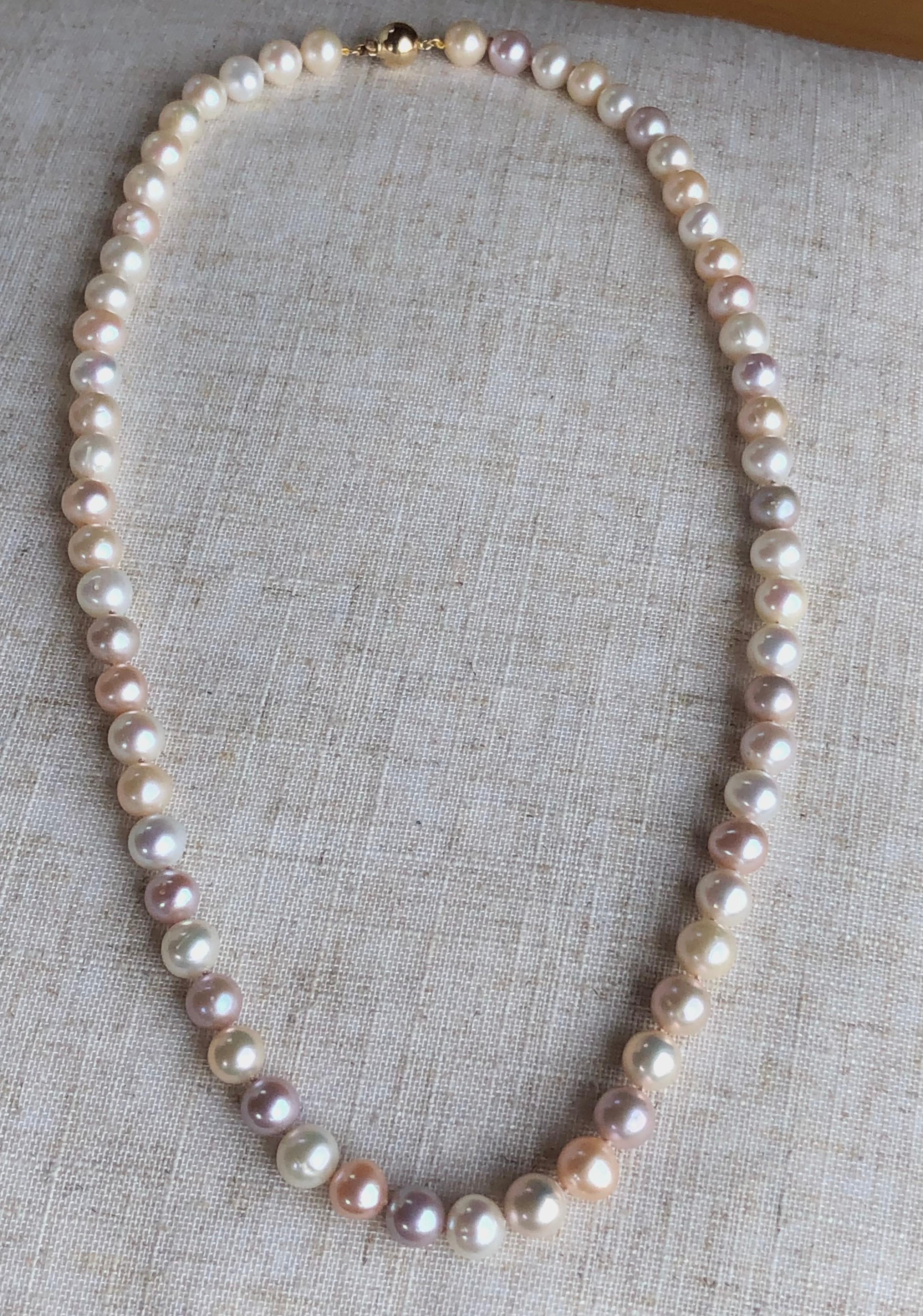 Cultured Lavander Pinkish Cream and White Pearl Necklace, pearls from 10mm to 10.5mm. Luster: very good and the necklace is finished with a round 14k yellow gold ball clasp. The stunning necklace is a 25-inch long. 
Note: Pearls have been
