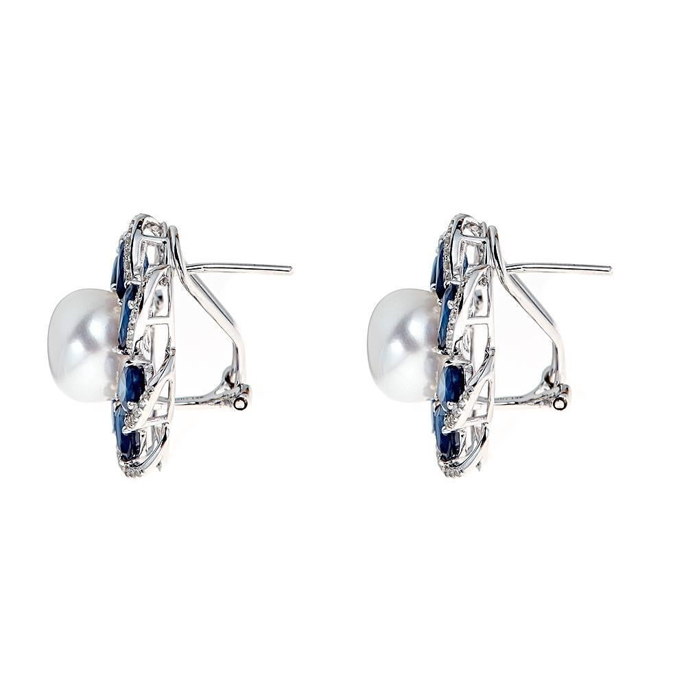 Handmade 14k white gold earrings with a 10mm pearl in the center surrounded by petals enhanced with pear shaped sapphires and approximately .48 CT in round diamonds.