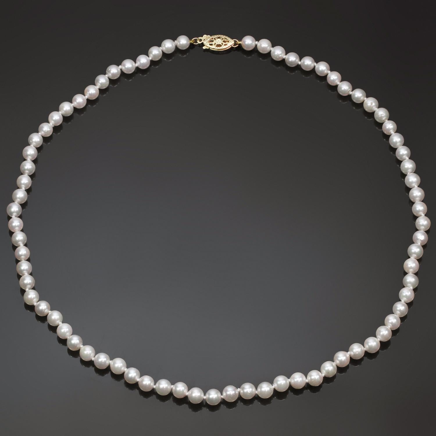 A classic strand of 5.0mm cultured pearls featuring a pinkish even color and very high luster. Completed by a ornamental filigree clasp in 14k yellow gold. Shiny and beautiful.  Measurements: 0.19