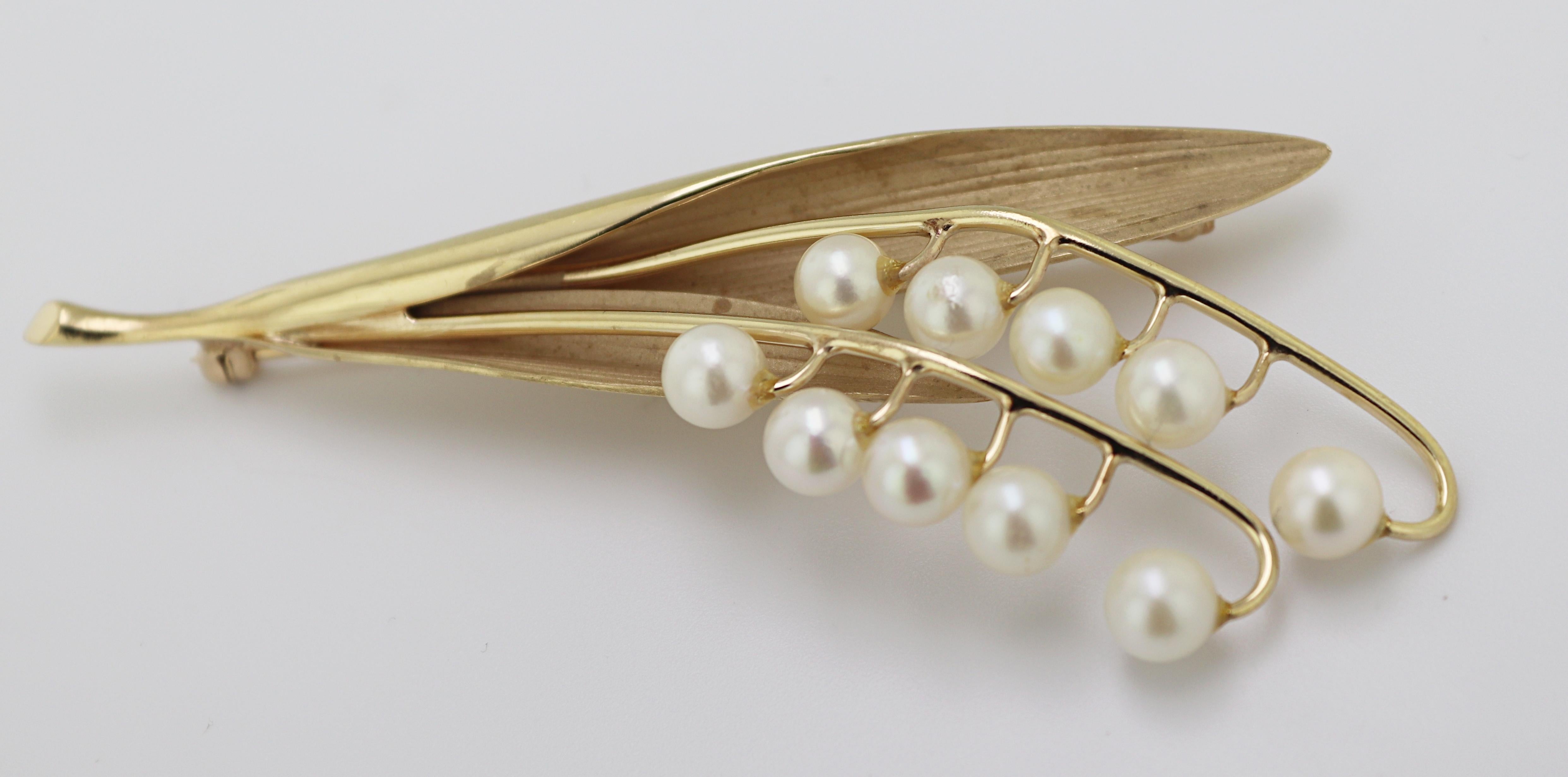 Designed a Lilly of the Valley, featuring (10) 5.5 mm cultured pearl flowers,
set in 14k yellow gold stem and leaves, 78.6 X 32 X 8.0 mm, marked CK
14K, Gross Weight: 12.54 grams.