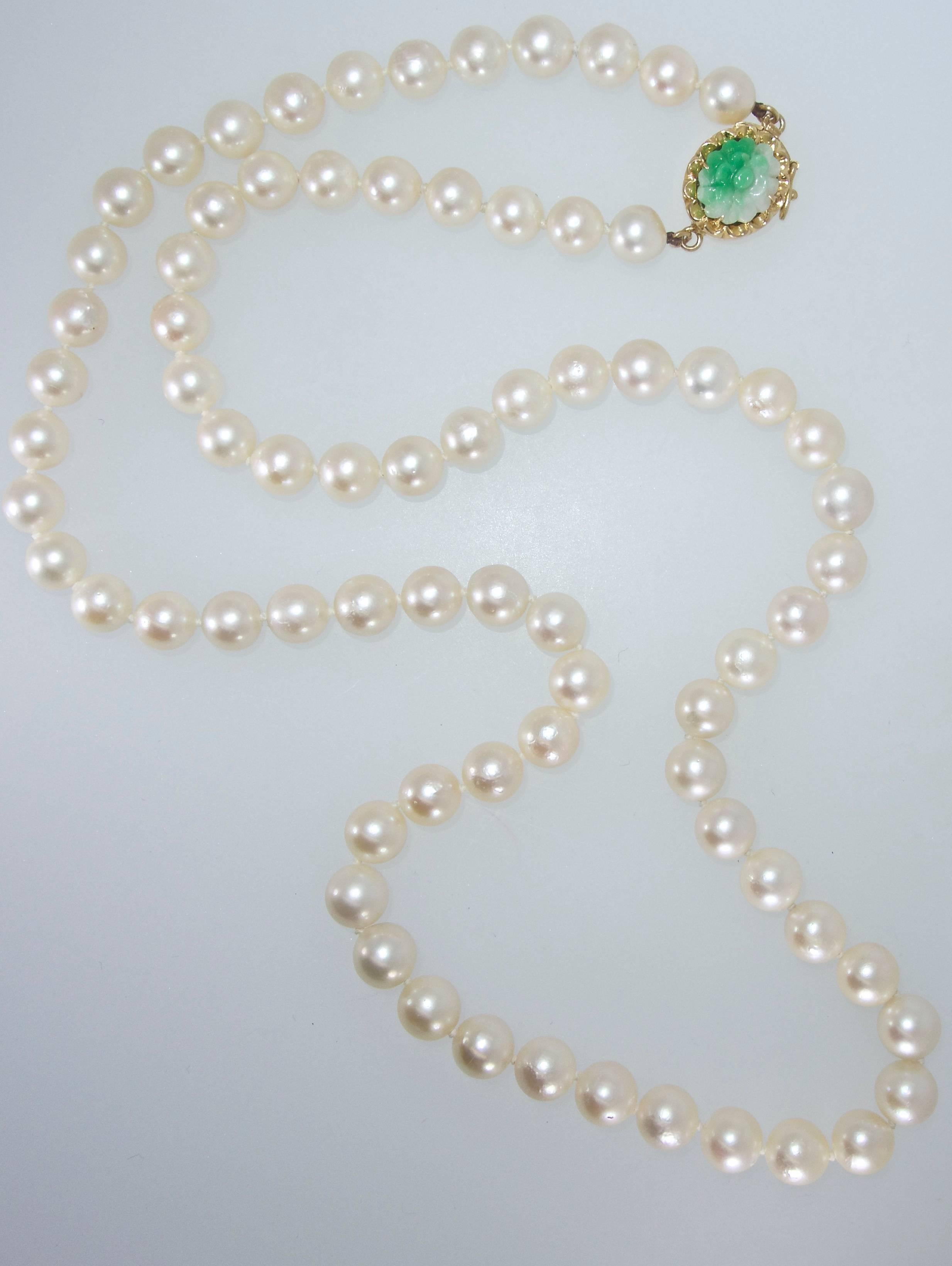 Cultured Akoya pearls ranging in size from 7 mm to 7.5 mm, fine luster,  22.5 inches in length and completed with a 14K gold and natural jadeite jade clasp.