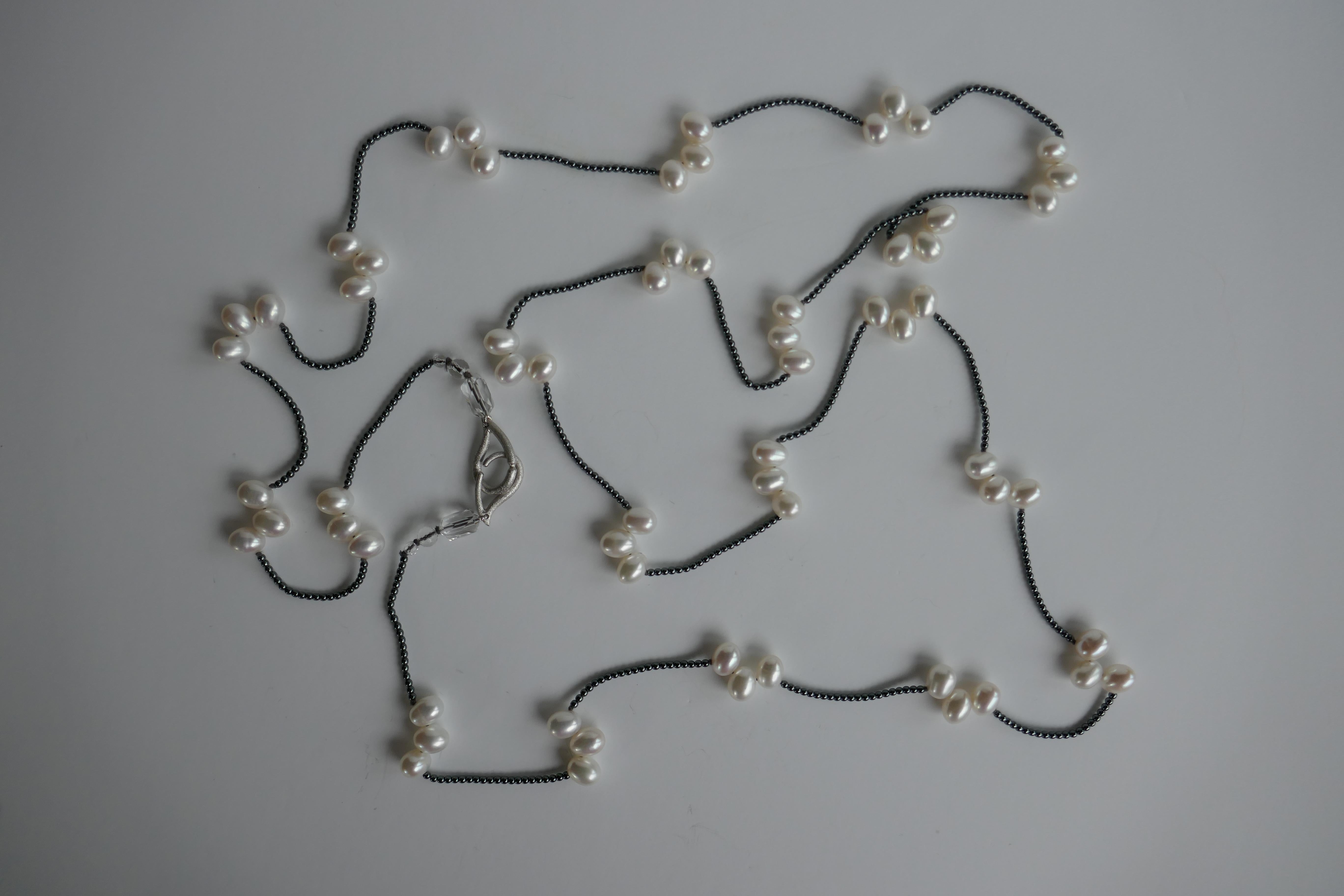 This necklace is made of 2mm hematite beads and white drop cultured pearls. It is finished with rock crystal and a 925 sterling silver clasp.  It is strung on grey silk thread and knotted. Besides being able to wear it six different ways it may also