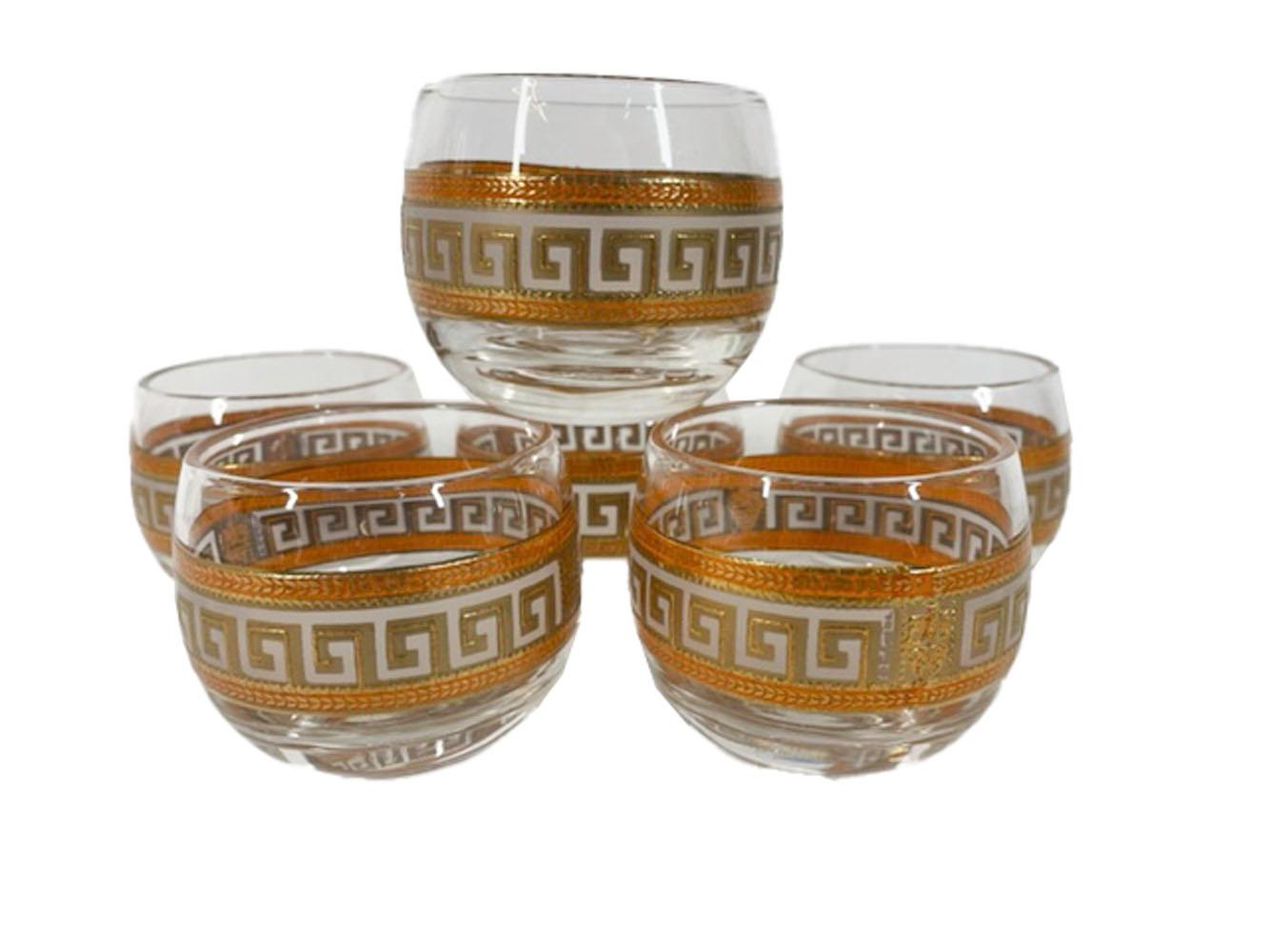 Mid-Century modern cocktail set consisting of cocktail pitcher w/stir rod and 6 roly poly cocktail glasses all decorated with Greek key and other classical motifs in translucent white and orange enamel with 22 karat gold.