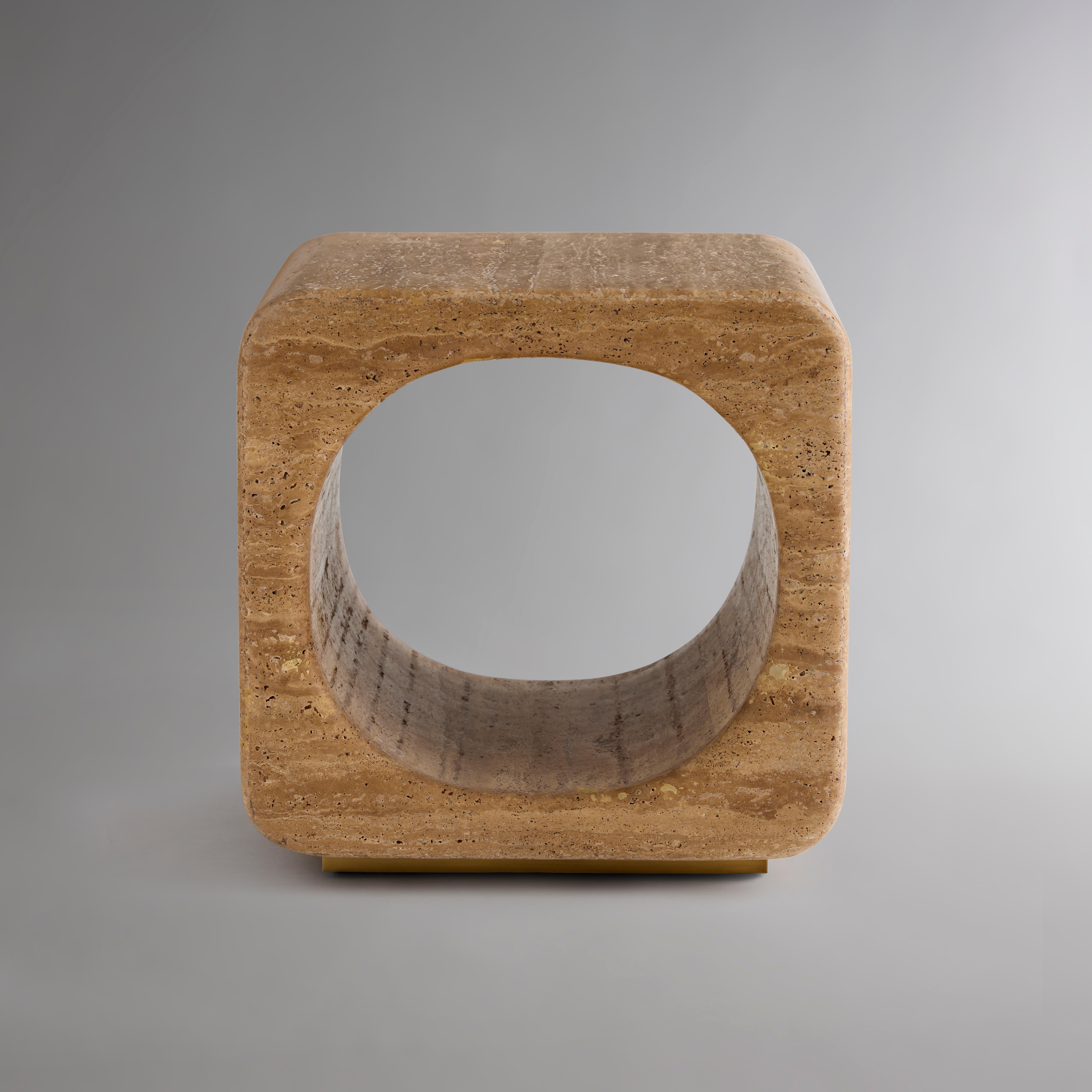 Available in three unique materials, this dynamic accent table harnesses the visual intrigue of smooth planes, careful contours, and perfect symmetry. Its form, a round-edged cube intersected centrally by a cylindrical void, evokes both stability