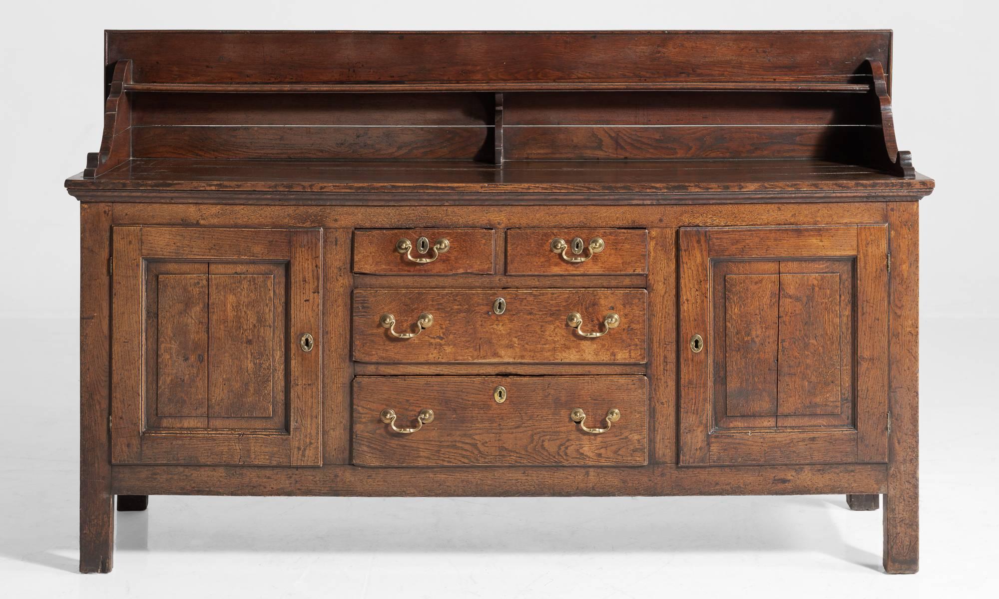 Cumberland oak dresser, circa 1790.

Georgian dresser with original color, panelled cupboard drawers and brass swan neck handles.

Measures: 35