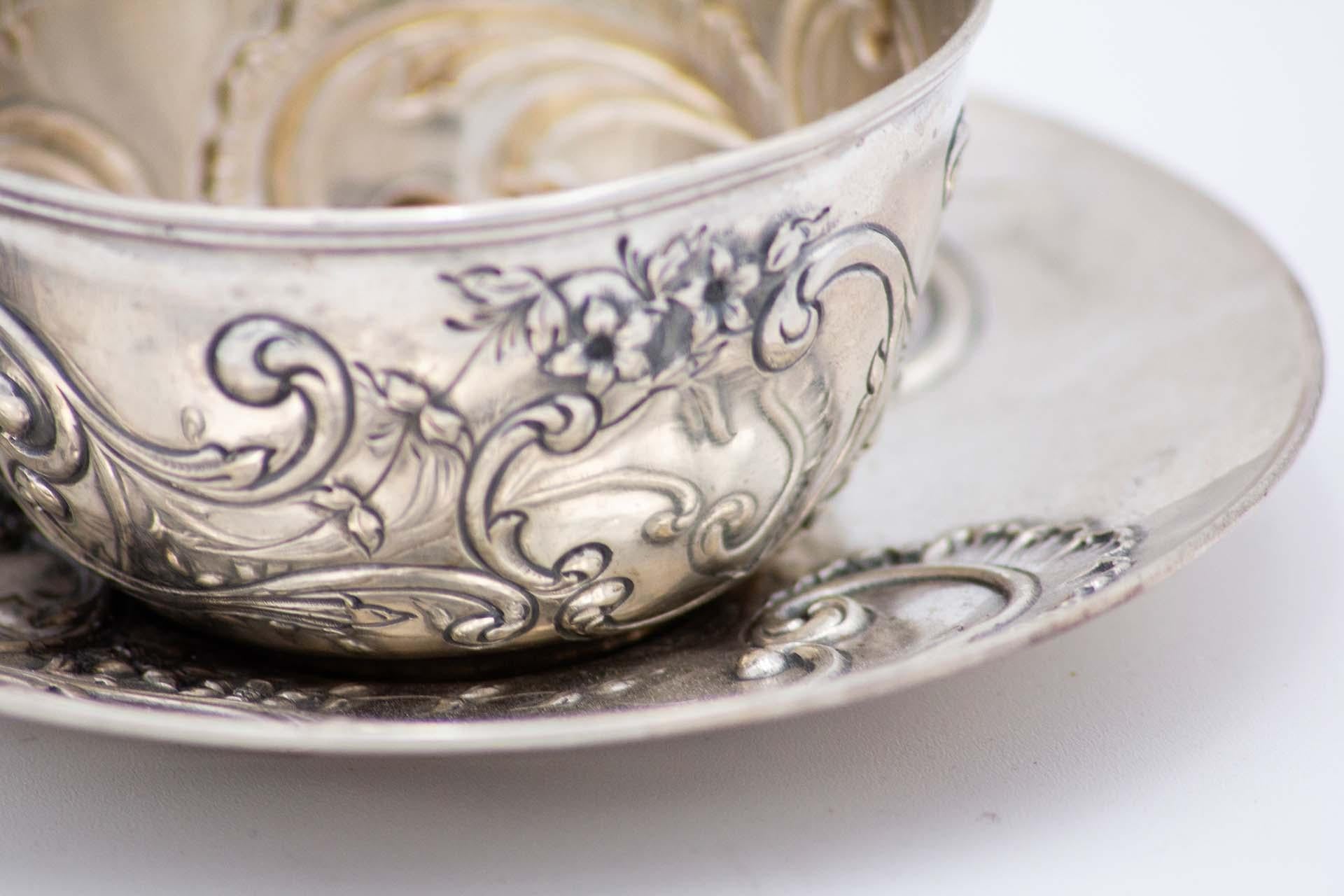 Description : Tasse et soucoupe en argent repoussé avec motifs floraux et guirlandes. Métal : Argent. Origine : Portugais. Marque : javali II Titre. Poids : 115,60 grammes. Dimensions : 12,2 cm x 5,7 cm : 12.2cmx5.7cm. Contenu : 833/1000. Marque de