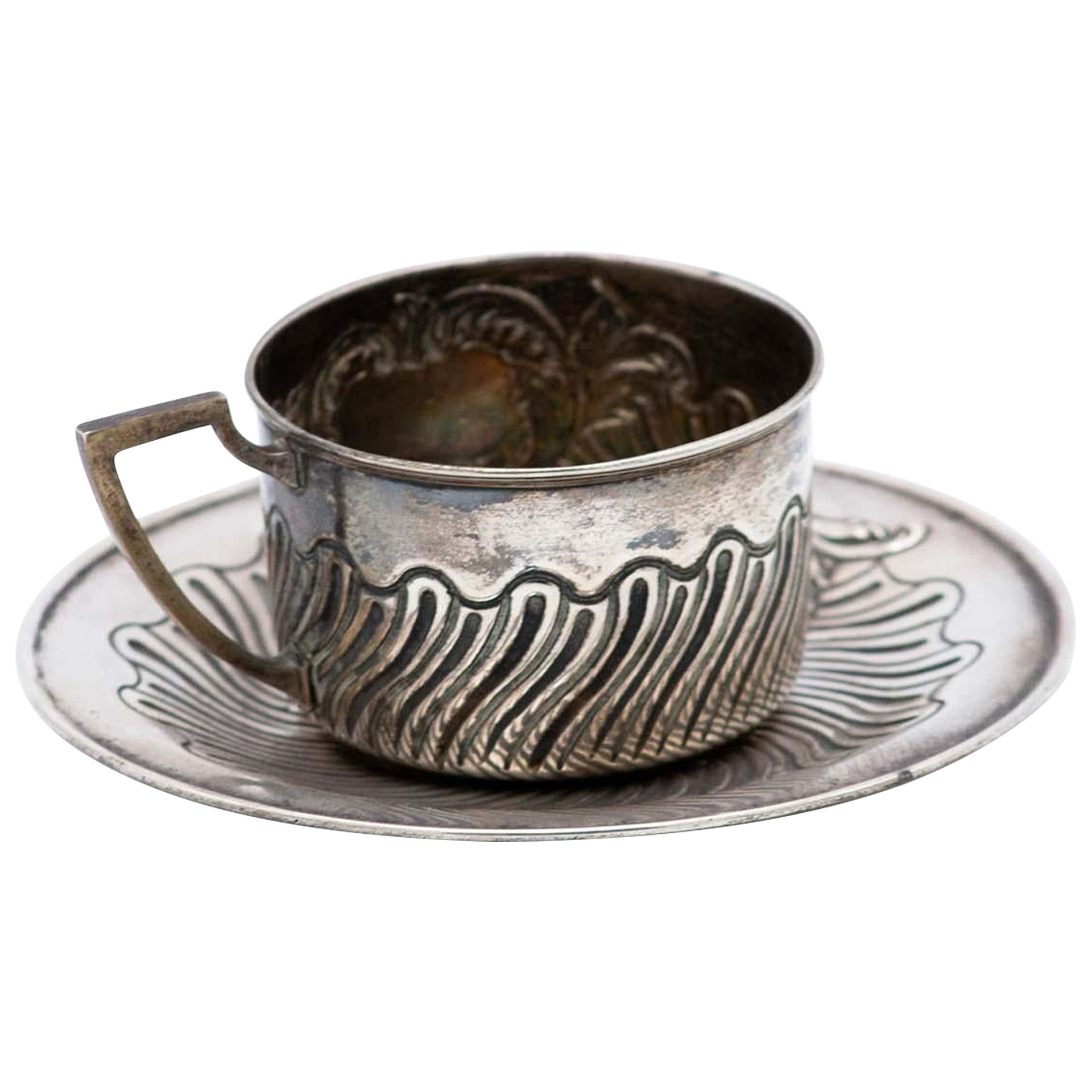 Cup and saucer in silver embossed with geometric figures and monogram card