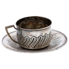 Cup and saucer in silver embossed with geometric figures and monogram card