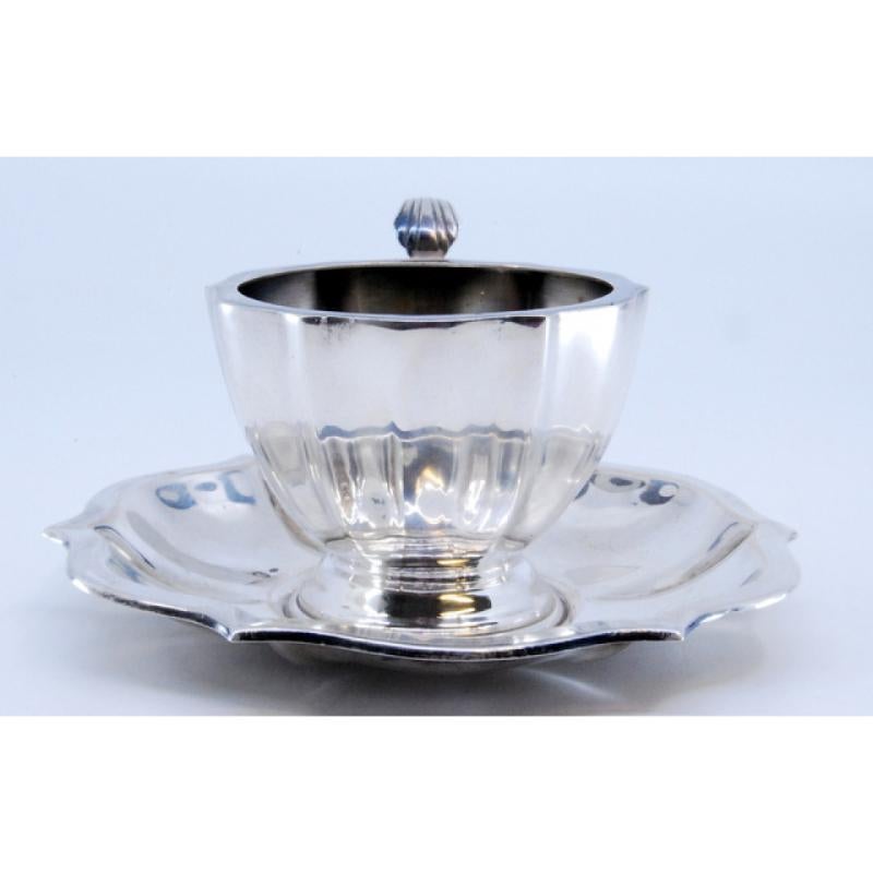 Description : Tasse et soucoupe en argent lisse avec nervures et poignée incurvée. Métal : Argent. Origine : hongroise. Marque : Diana's Head. Poids : 101,57 grammes (tasse et soucoupe). Dimensions : 11x11cm. Contenu : 800/1000. Marque d'essai :