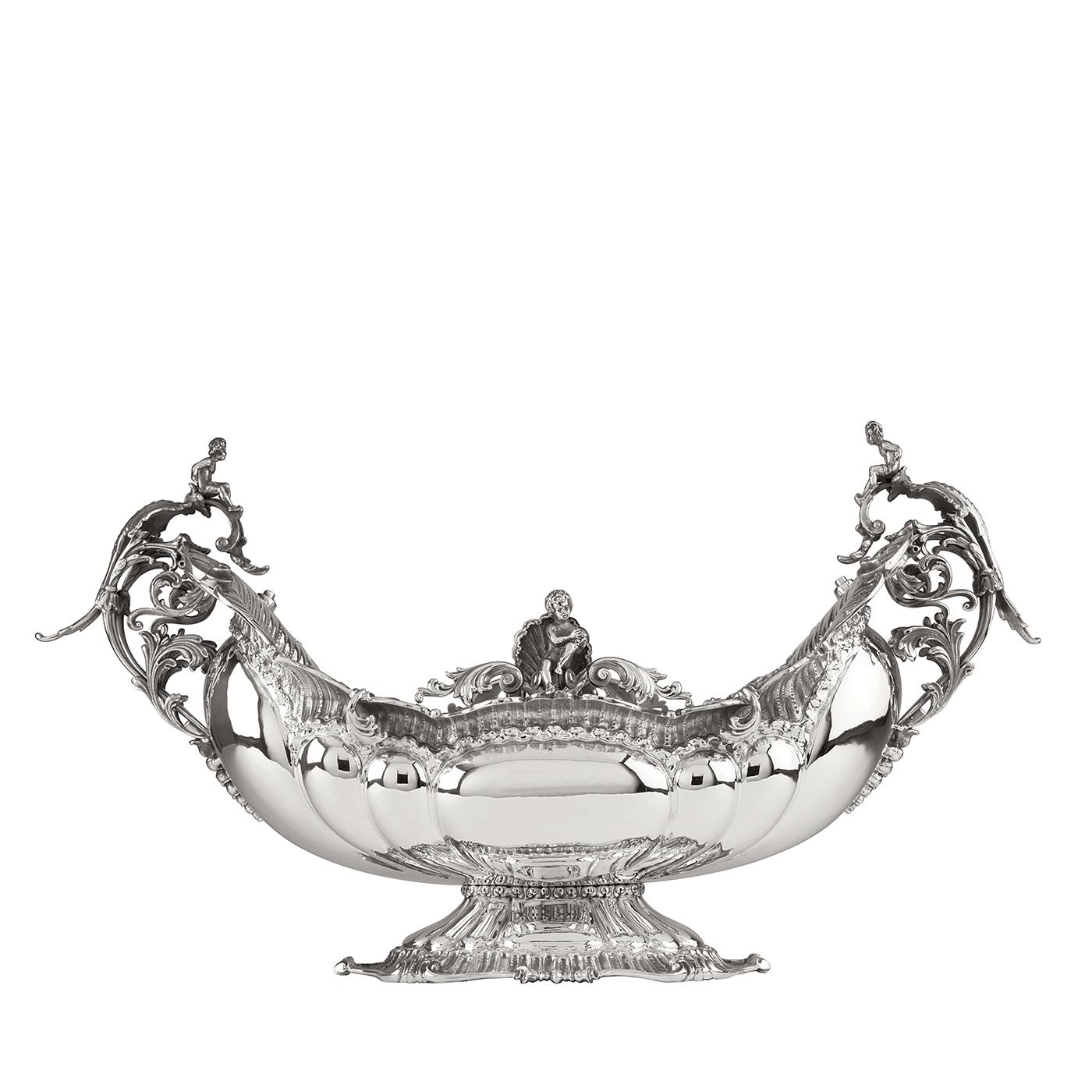 This splendid silver centrepiece has the unique and magnificent shape of a trophy, whose symmetrical shape is sinuous and luxurious. Its surface is smooth and is adorned throughout the base and at the top edge of the cup with an elaborate decoration