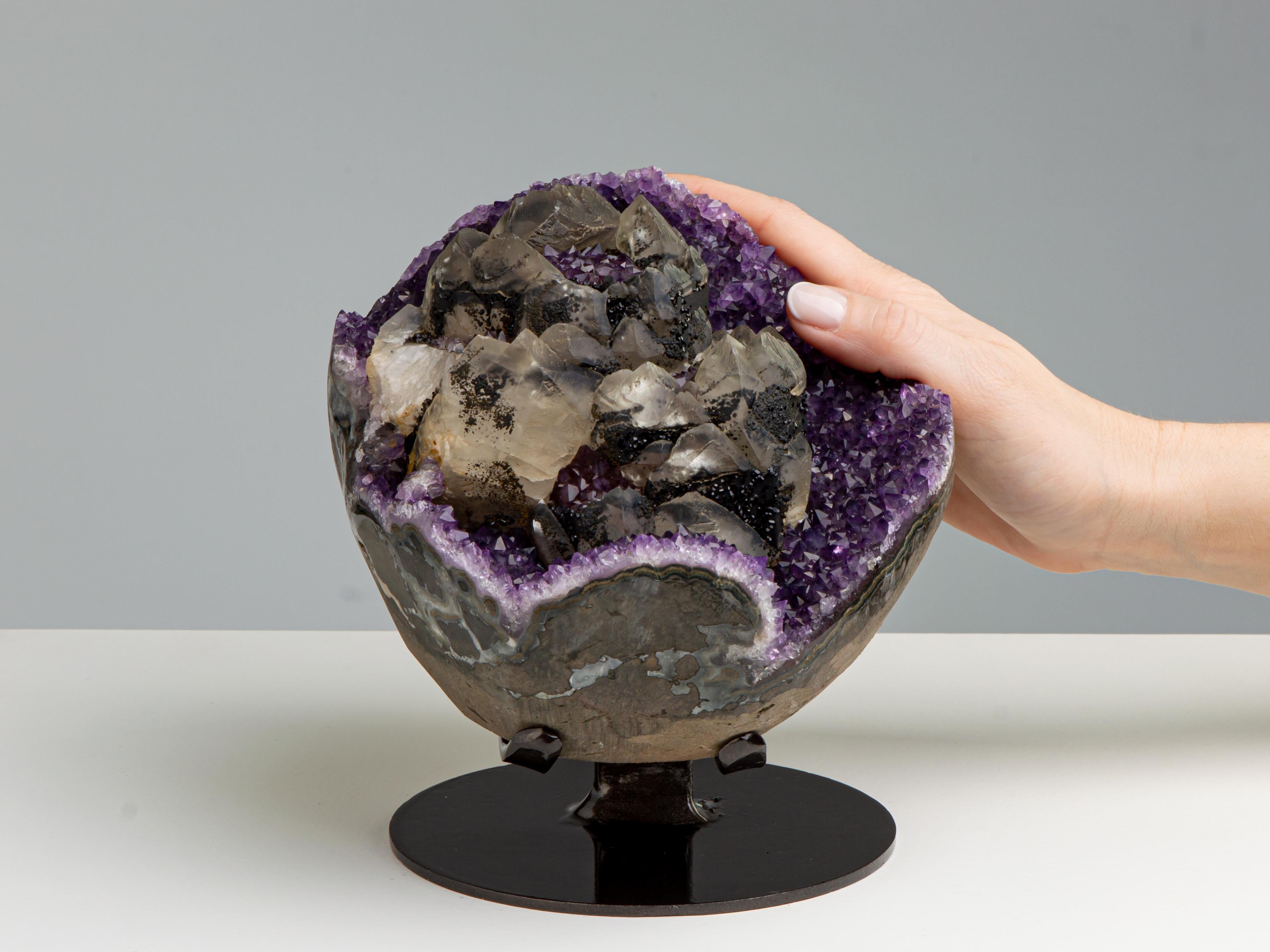 Assomigliando a una coppa di fiori, questa formazione è composta da diversi elementi circolari.
Le composizioni di calcite erano adagiate su un letto di ametista viola intenso. C'è un
crescita di seconda generazione del quarzo ametista all'interno