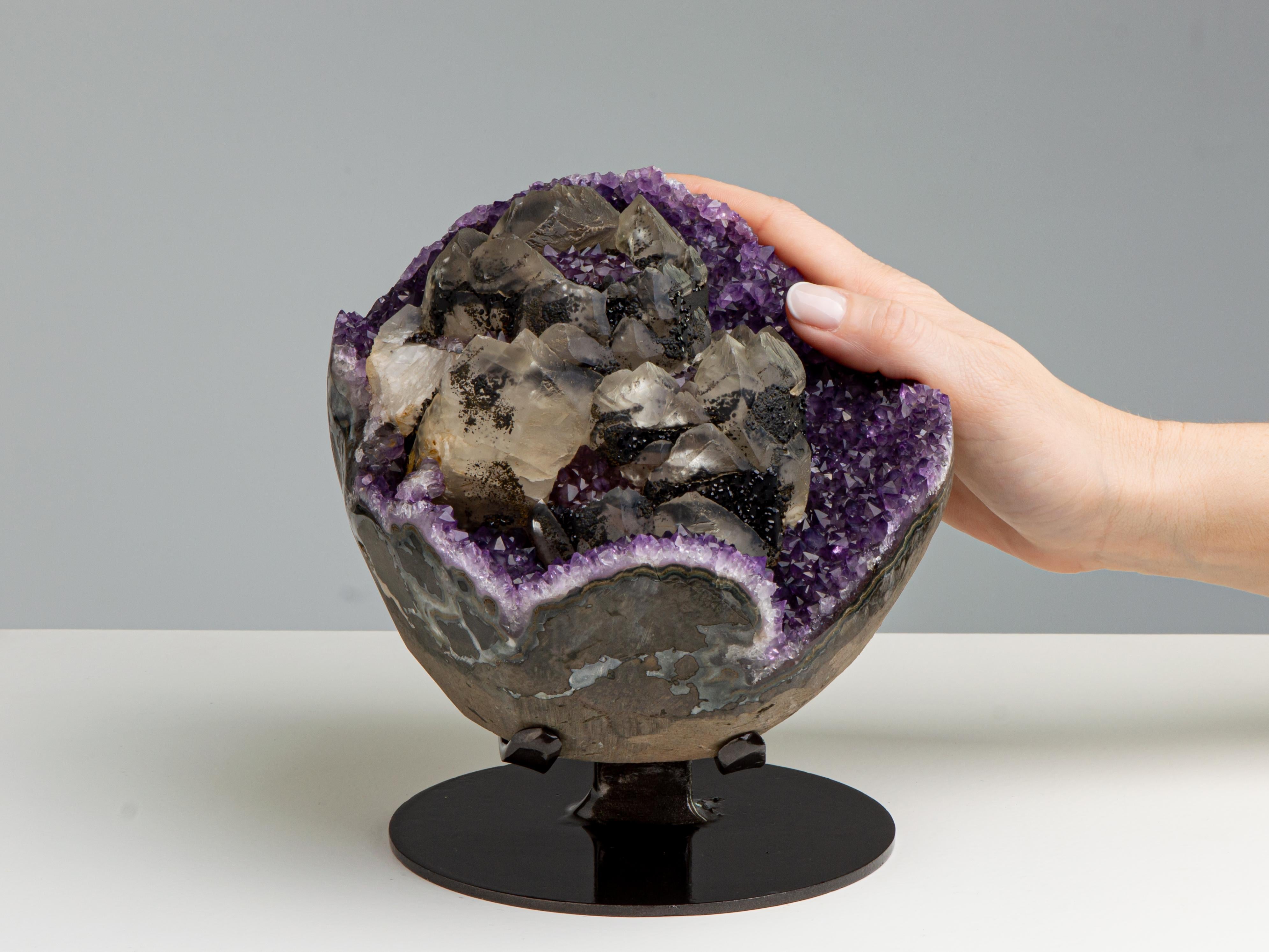 Resembling a cup of flowers, this formation consists of several circular
calcite arrangements sat on a bed of deep purple amethyst. There is a
second generation growth of amethystine quartz within and around the
circular calcites, with overgrowth