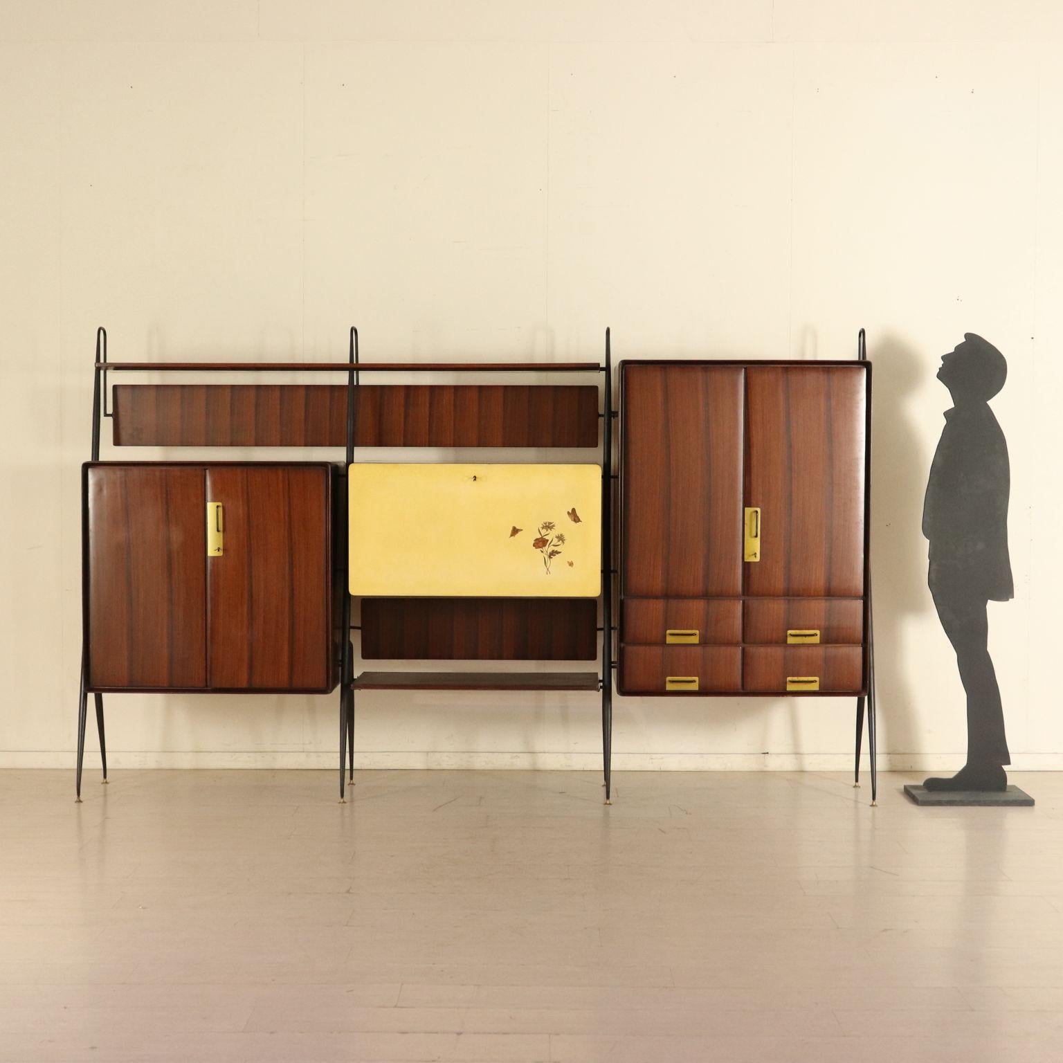A cupboard with hinged and drop-leaf doors designed by Silvio Cavatorta. Teak veneer, lacquered doors with flower decoration, brass handles and badges, lacquered metal uprights. Manufactured in Italy, 1960s.