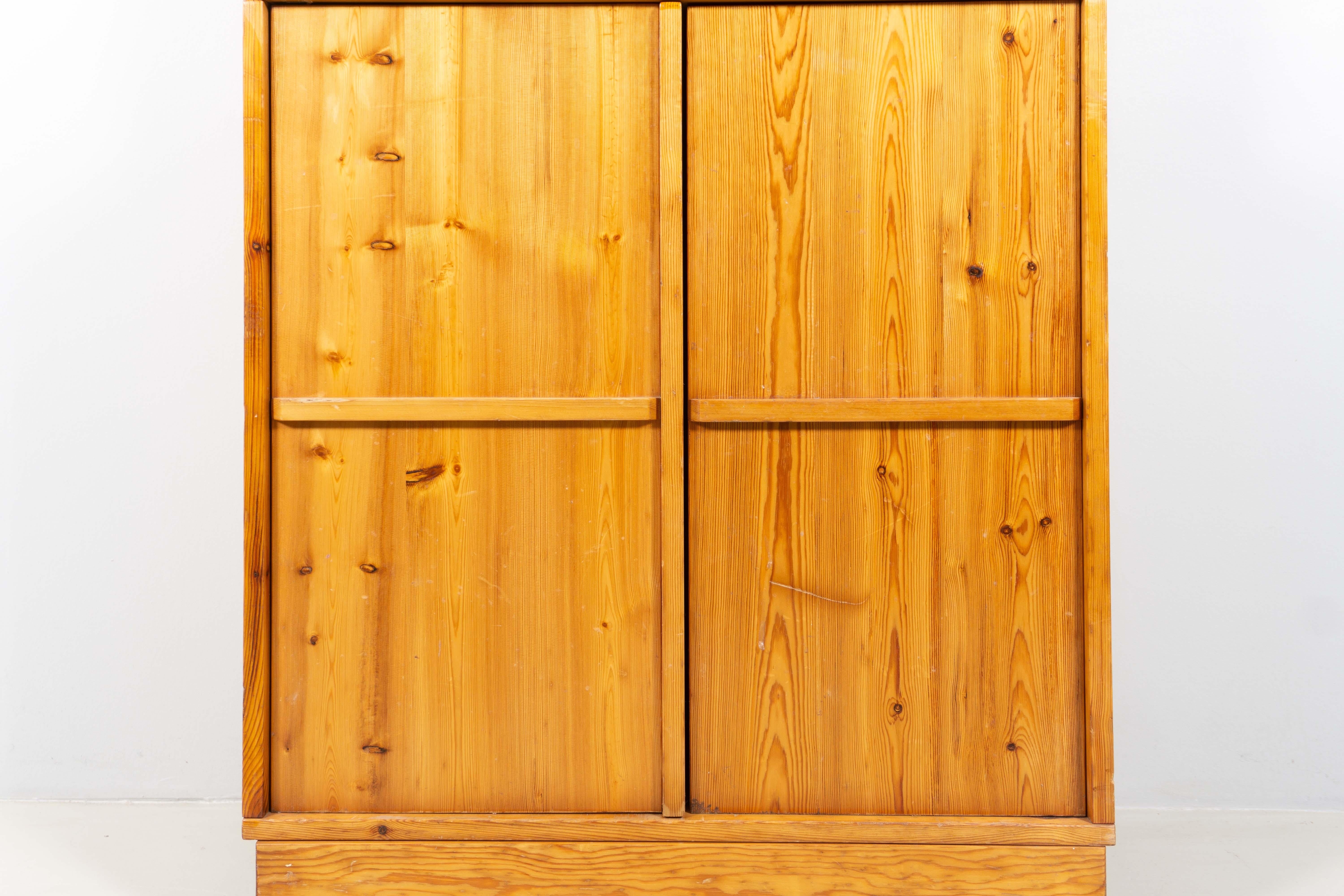 Gianfranco Fini designed this beautiful cupboard in 1972. It convinces with its puristic, beautiful proportion and consists of two pieces. The bottom part differs from the upper part because of its depth and two doors. Behind the door is another