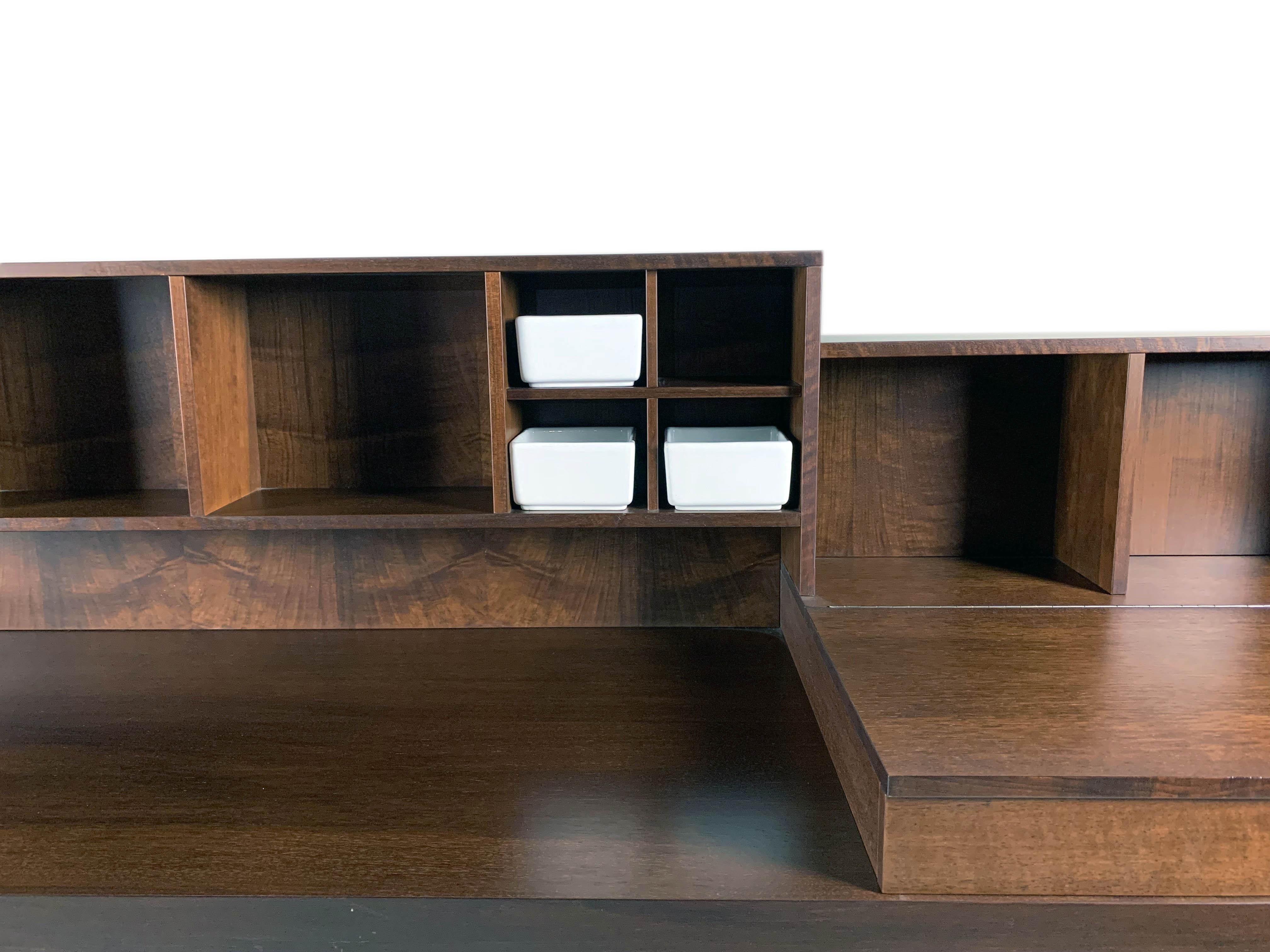 Pranzo est une armoire clairement inspirée de la tradition de l'ébénisterie lombarde en bois de noyer, reflétant l'approche essentielle de Silvio Canne en matière de design ; un design exempt d'excès stylistiques éphémères et axé sur la durabilité