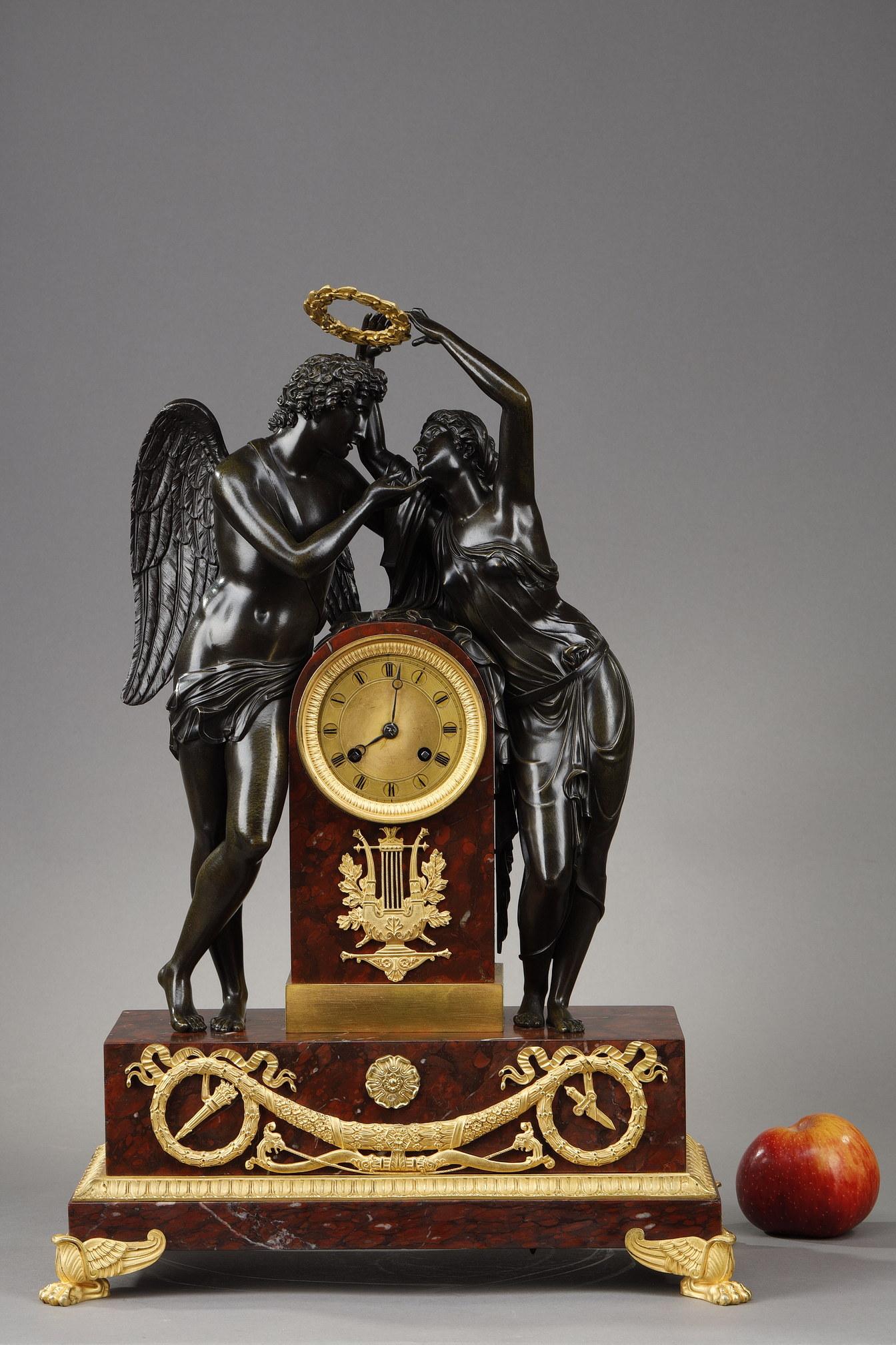 Clock representing the Coronation of Love or Love and Psyche after Claude Michallon. Psyche, dressed in a wet drapery held by a belt, leans over the central pillar in griotte marble to crown Amour, recognizable by his wings and his quiver at his
